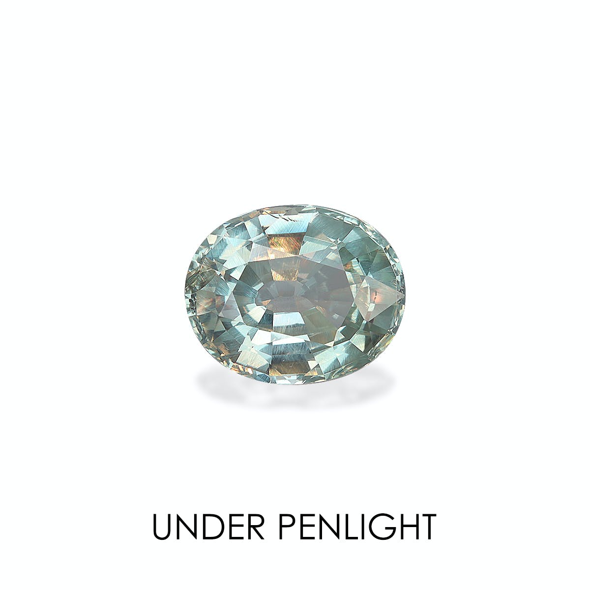 Une alexandrite ovale facettée (2,31 carats) d'une teinte vert-bleu pâle se détache sur un fond blanc, laissant apparaître des reflets sous un projecteur. En dessous, on peut lire « UNDER PENLIGHT » de Bonnot Paris.