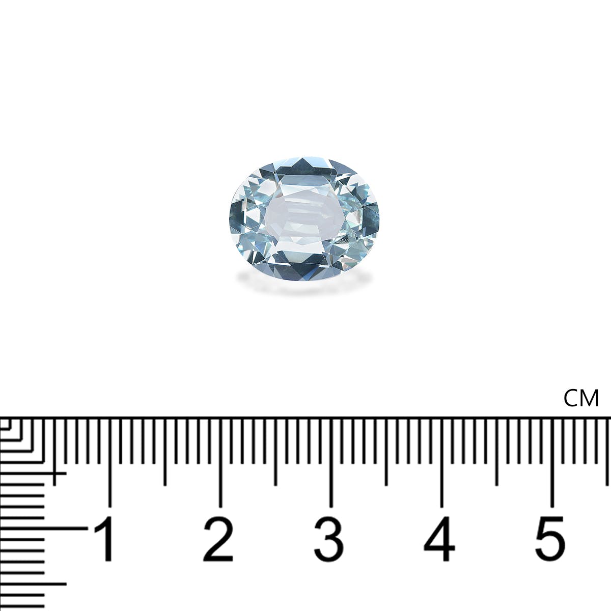 Une petite Aigue-Marine ovale de 5,23 carats de Bonnot Paris repose gracieusement sur une surface blanche, sous laquelle est posée une règle. La règle, graduée en centimètres, indique les dimensions de la pierre : environ 1,5 cm de long, dans son ravissant ton bleu clair.