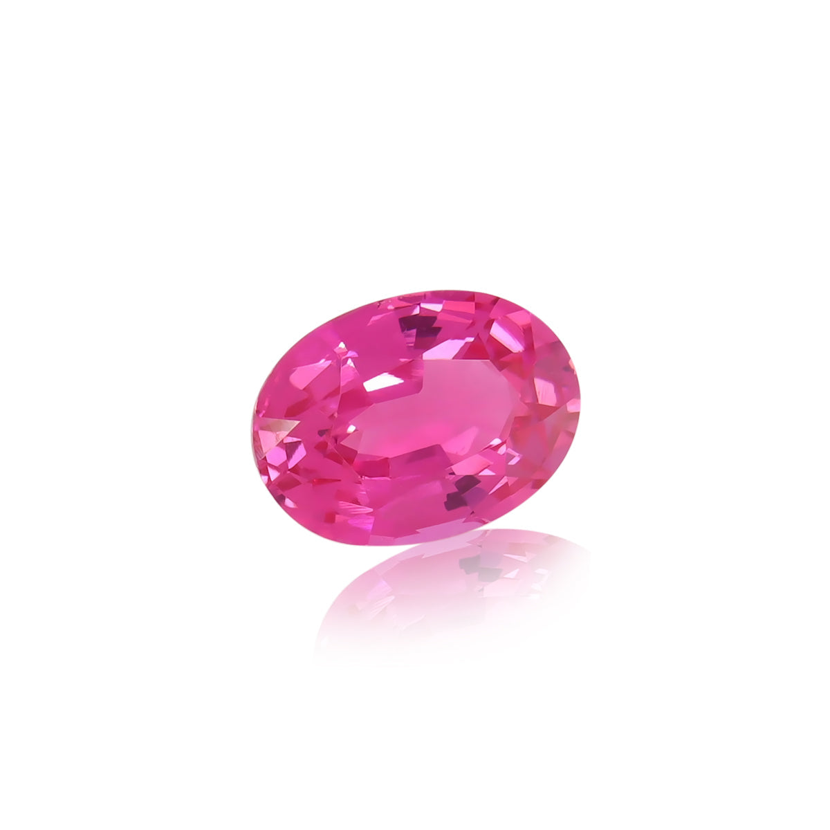 Un Spinelle Mahenge brillant de forme ovale pesant 2,12 ct, de Nascendi Paris, avec une teinte rose éclatante et des facettes réfléchissant la lumière serties sur un fond blanc uni, projette une ombre subtile en dessous pour rehausser sa couleur vibrante et son éclat.