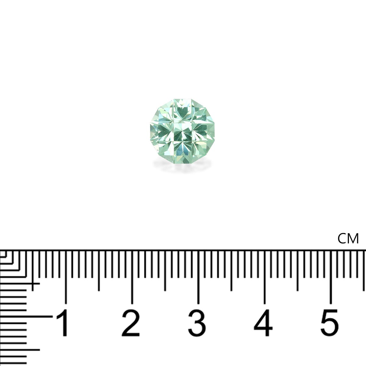 Une petite tourmaline paraïba verte, ronde et de Bonnot Paris, est posée sur un fond blanc. Une règle graduée en centimètres en dessous indique un diamètre d'environ 1 cm.