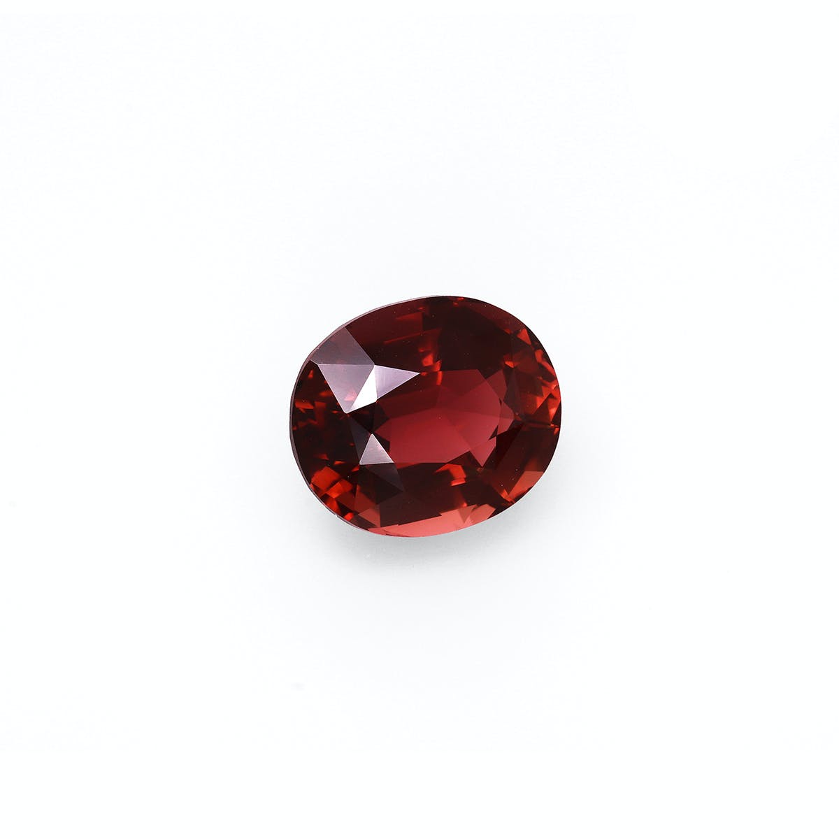 Une Tourmaline Pourpre facettée de forme ovale · 7,68 ct de Bonnot Paris repose sur un fond blanc uni, mettant en valeur sa teinte rouge foncé avec des reflets et des reflets visibles de sa surface polie.