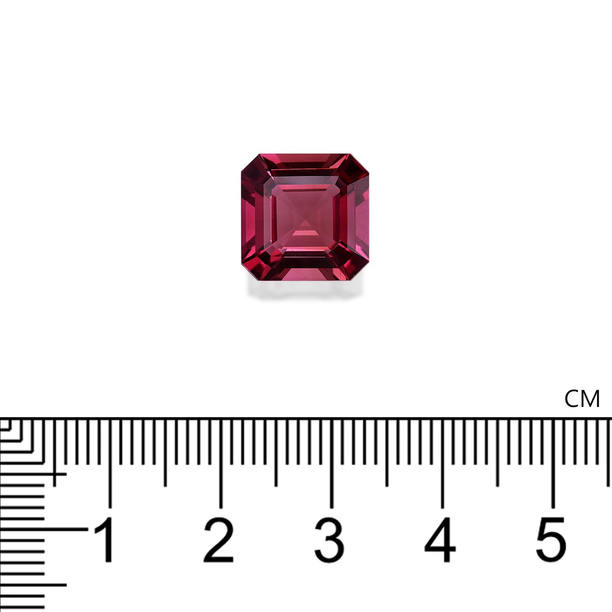 Une petite Tourmaline Rose rectangulaire rouge foncé · 6,58 ct de Bonnot Paris est placée sur un fond blanc, avec une règle centimétrique indiquant que sa largeur est d'un peu plus de 0,5 cm.