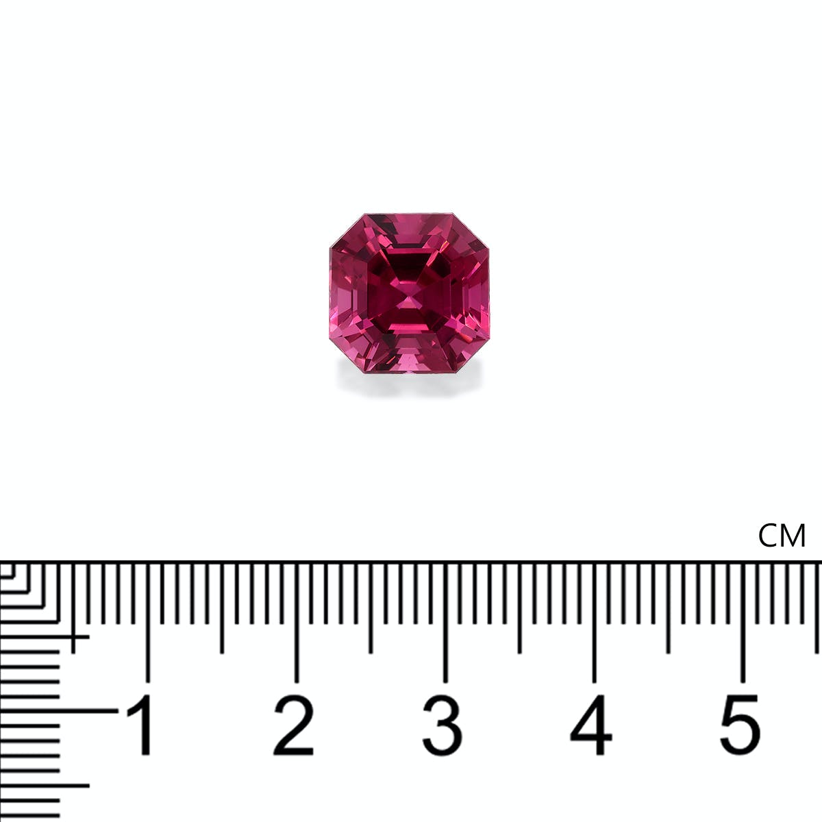 Une petite tourmaline rose octogonale de Bonnot Paris est placée au-dessus d'une règle graduée. Elle semble mesurer environ 0,8 cm de large, présenter une couleur rouge profond et une taille facettée qui reflète magnifiquement la lumière.