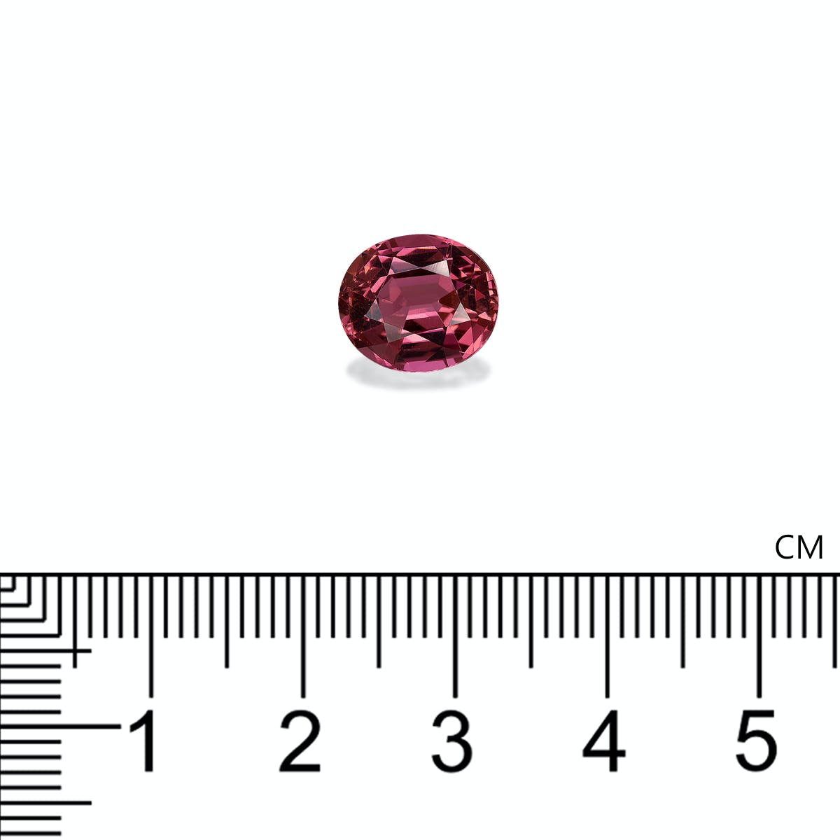 Une petite tourmaline rose ovale de Bonnot Paris, d'un rose profond et pesant 3,66 carats, est sertie sur un fond blanc. En dessous, une règle noire graduée en centimètres indique que la pierre mesure environ 1,2 cm.