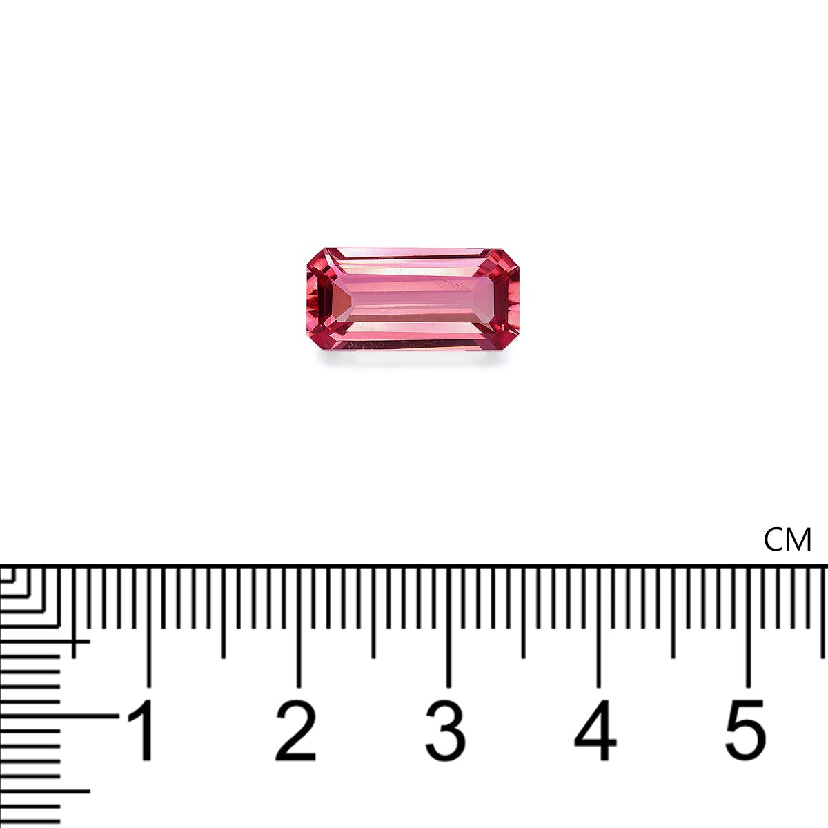 Une tourmaline rose de 3,95 carats de Bonnot Paris, mesurant un peu plus d'1 cm, est présentée sur une règle graduée en centimètres. Cette pierre rectangulaire rose aux bords biseautés reflète magnifiquement la lumière, soulignant sa clarté et sa couleur.