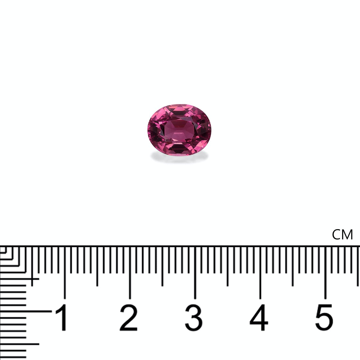 La Tourmaline Rose Bonnot Paris, une pierre rose ovale de 3,31 carats, repose sur une surface blanche. Une règle située en dessous indique que la pierre mesure moins de 2 cm de large.