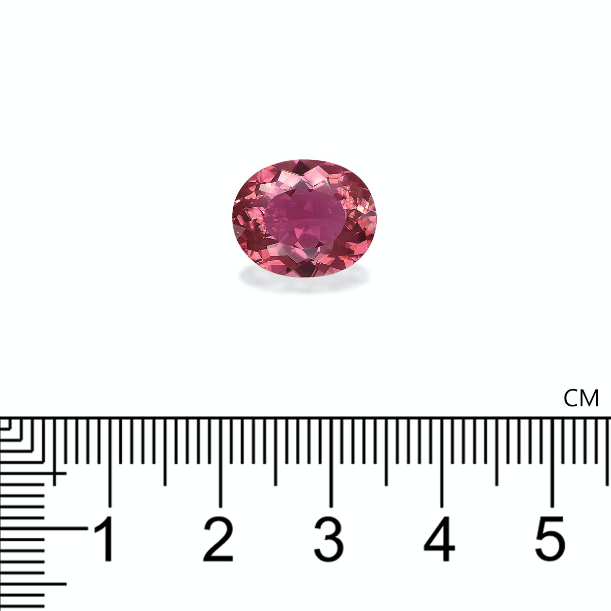 Une Tourmaline Rose ovale de 4,88 carats de Bonnot Paris est présentée sur une surface blanche avec une règle en dessous, indiquant que sa largeur est d'un peu plus de 1 cm.