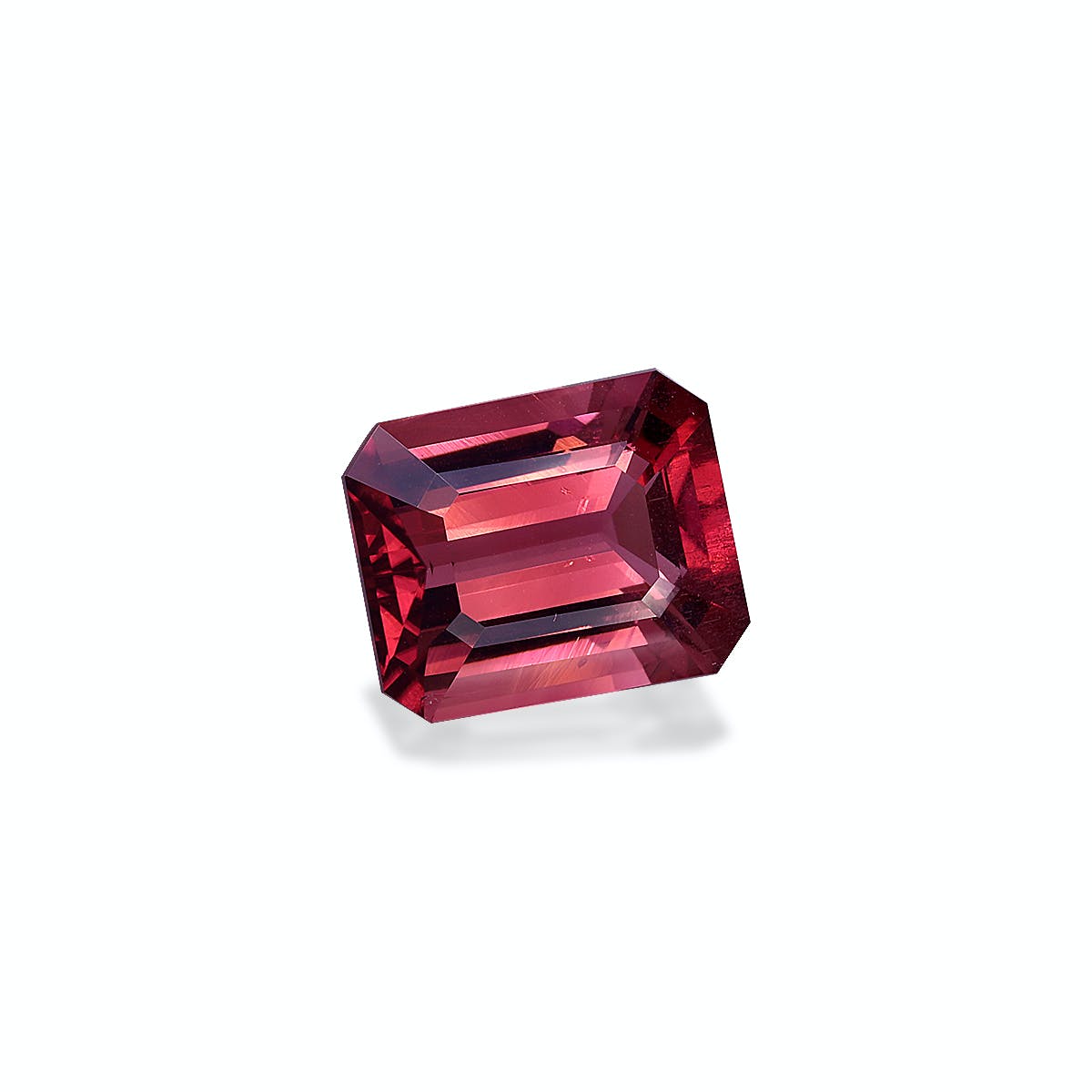 La Tourmaline Rose, une pierre précieuse de 5,73 carats de Bonnot Paris, est rectangulaire aux bords biseautés. Ses teintes rouge profond et ses facettes réfléchissant la lumière se détachent sur un fond blanc uni.