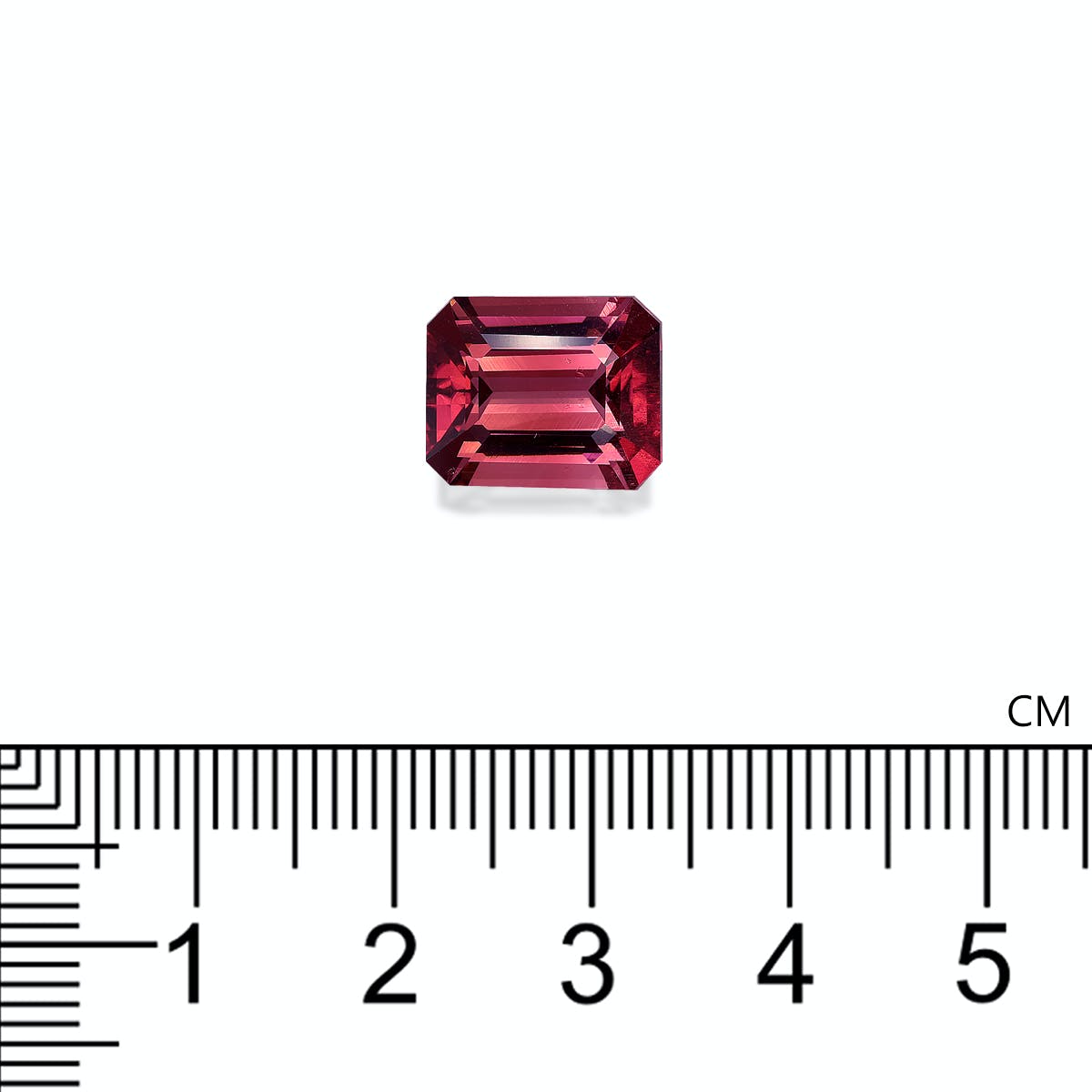 Une tourmaline rose rouge de 5,73 carats, taille émeraude, de Bonnot Paris, est présentée sur fond blanc. Une règle en centimètres sous la pierre précieuse indique sa largeur d'environ 1 cm.