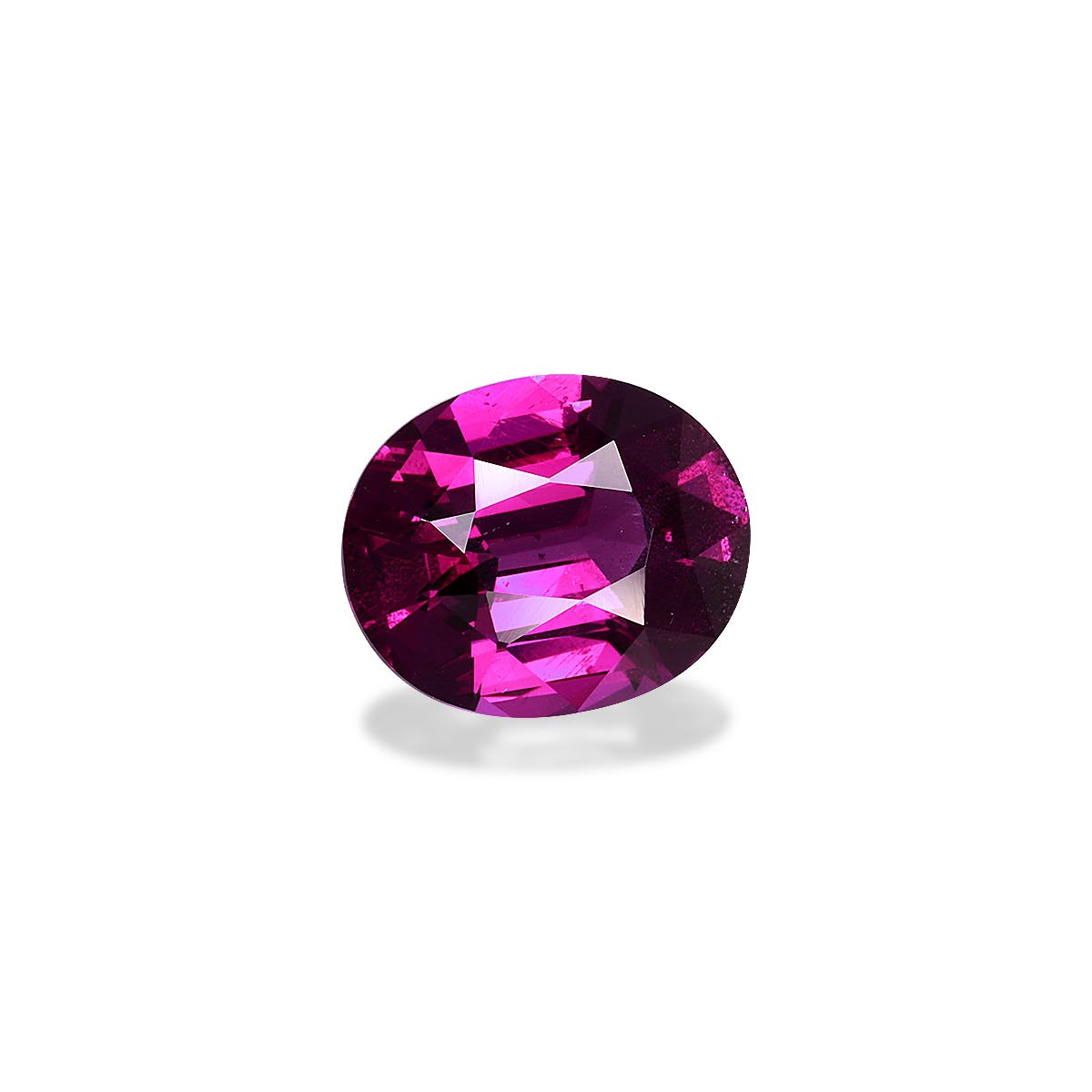 Le Grenat Umbalite de Bonnot Paris présente une pierre précieuse magenta vibrante de forme ovale pesant 4,41 ct, avec des facettes visibles reflétant la lumière et projetant une ombre subtile sur un fond blanc uni.