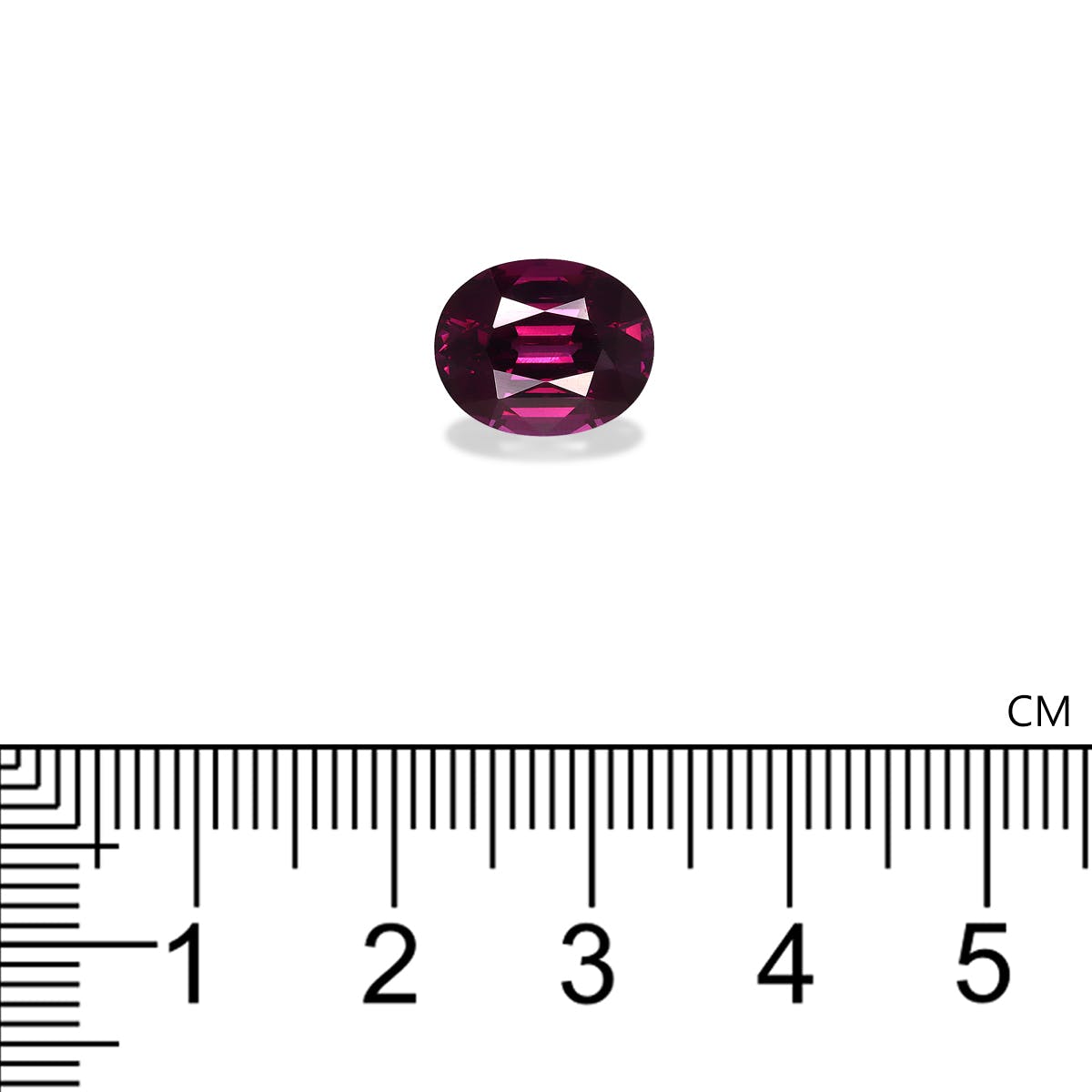 Une petite gemme violette de forme ovale présentée sur un fond blanc avec une règle centimétrique en dessous pour l'échelle, révélant que le Grenat Umbalite de Bonnot Paris mesure environ 1 cm de long et pèse 4,82 ct.