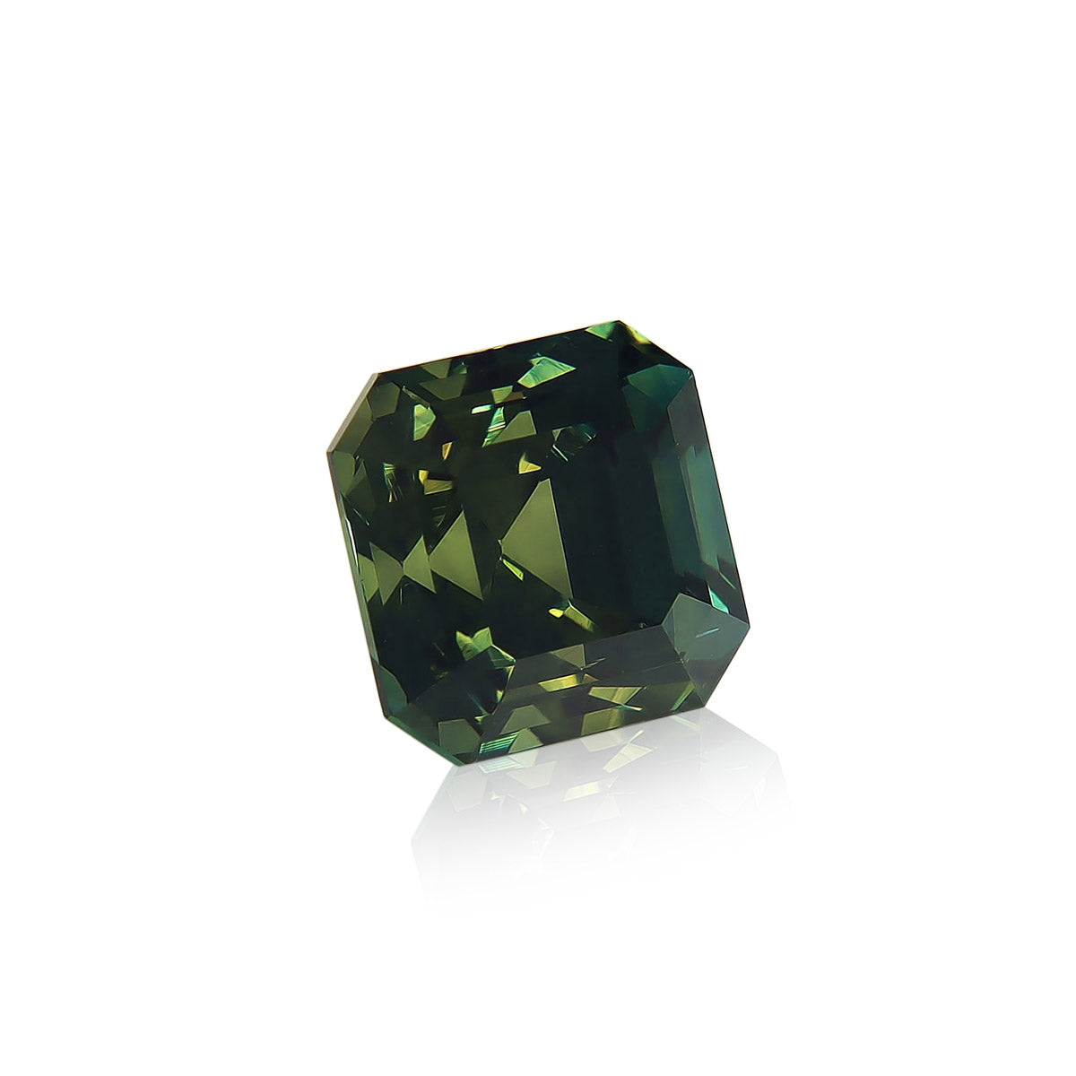 Le Saphir Vert · 6,53ct de Bonnot Paris est une pierre précieuse verte rectangulaire et multifacette avec une surface brillante et diverses nuances vertes, photographiée sur un fond blanc avec un léger reflet en dessous.