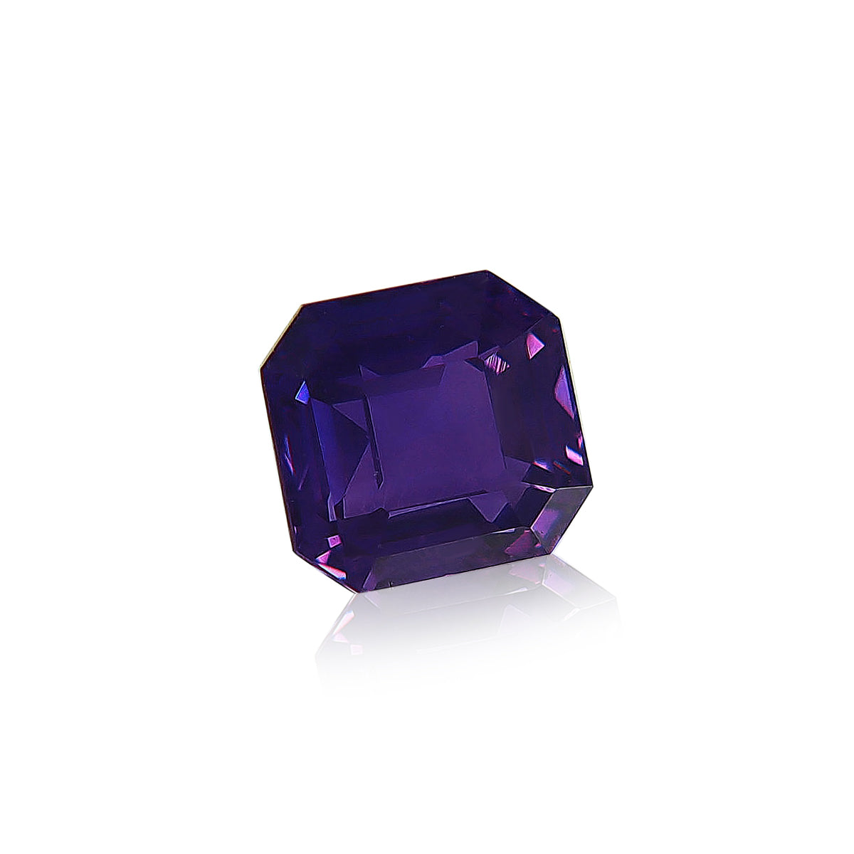 Le Saphir Violet de Bonnot Paris est une pierre précieuse rectangulaire facettée de 1,65 carat, d'une teinte bleu-violet profond, offrant de subtils reflets lumineux. Évoquant les plus beaux saphirs de Madagascar, il présente une clarté exceptionnelle et est taillé sur un fond blanc.