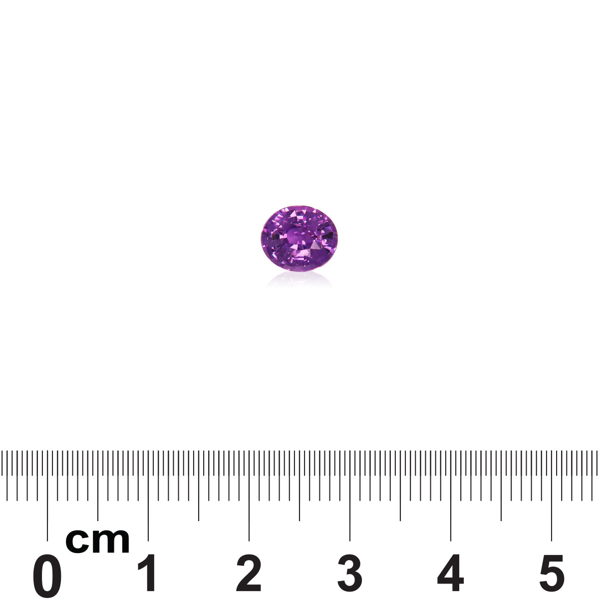 Une petite pierre précieuse ronde Saphir Violet de 1,61 carat de Bonnot Paris est posée sur un fond blanc. En dessous, une règle graduée en centimètres indique que la pierre mesure environ 0,6 cm de diamètre.