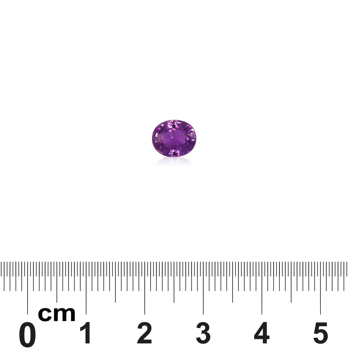 La pierre précieuse Saphir Violet de 1,51 ct de Bonnot Paris, de forme ovale et violette, est présentée sur un fond blanc uni au-dessus d'une règle métrique pour l'échelle en centimètres, mettant en valeur sa surface polie qui reflète la lumière.