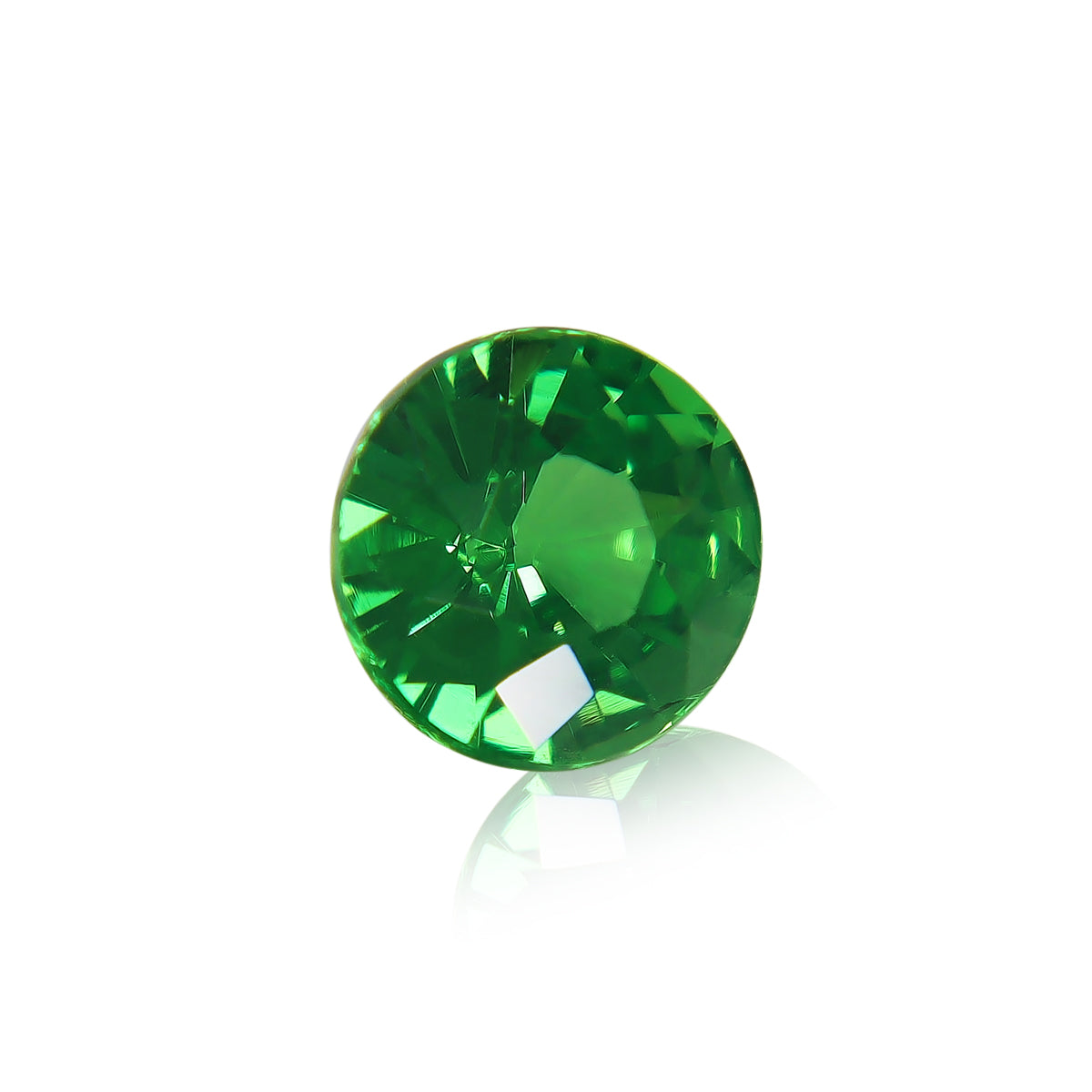 Gros plan de la Grenat Tsavorite Bonnot Paris, une pierre précieuse verte ronde facettée de 1,49 ct avec une surface brillante, réfléchissant la lumière et projetant une ombre subtile sur un fond blanc.