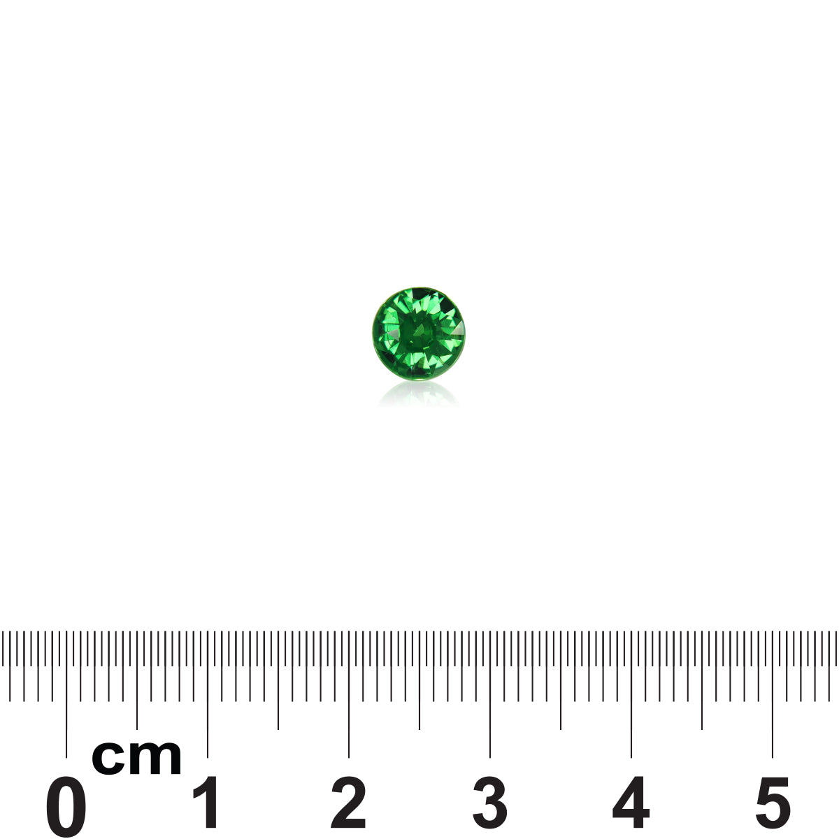 Une petite pierre précieuse ronde Grenat Tsavorite de Bonnot Paris est posée sur un fond blanc au-dessus d'une règle centimétrique, mesurant environ 0,5 cm de diamètre avec une teinte verte vibrante.