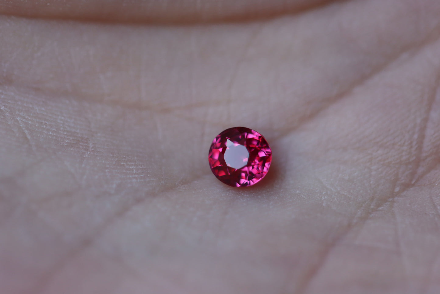 Un petit Rubis du Mozambique rond facetté (1,02 ct) de Bonnot Paris, posé sur la paume d'une main.