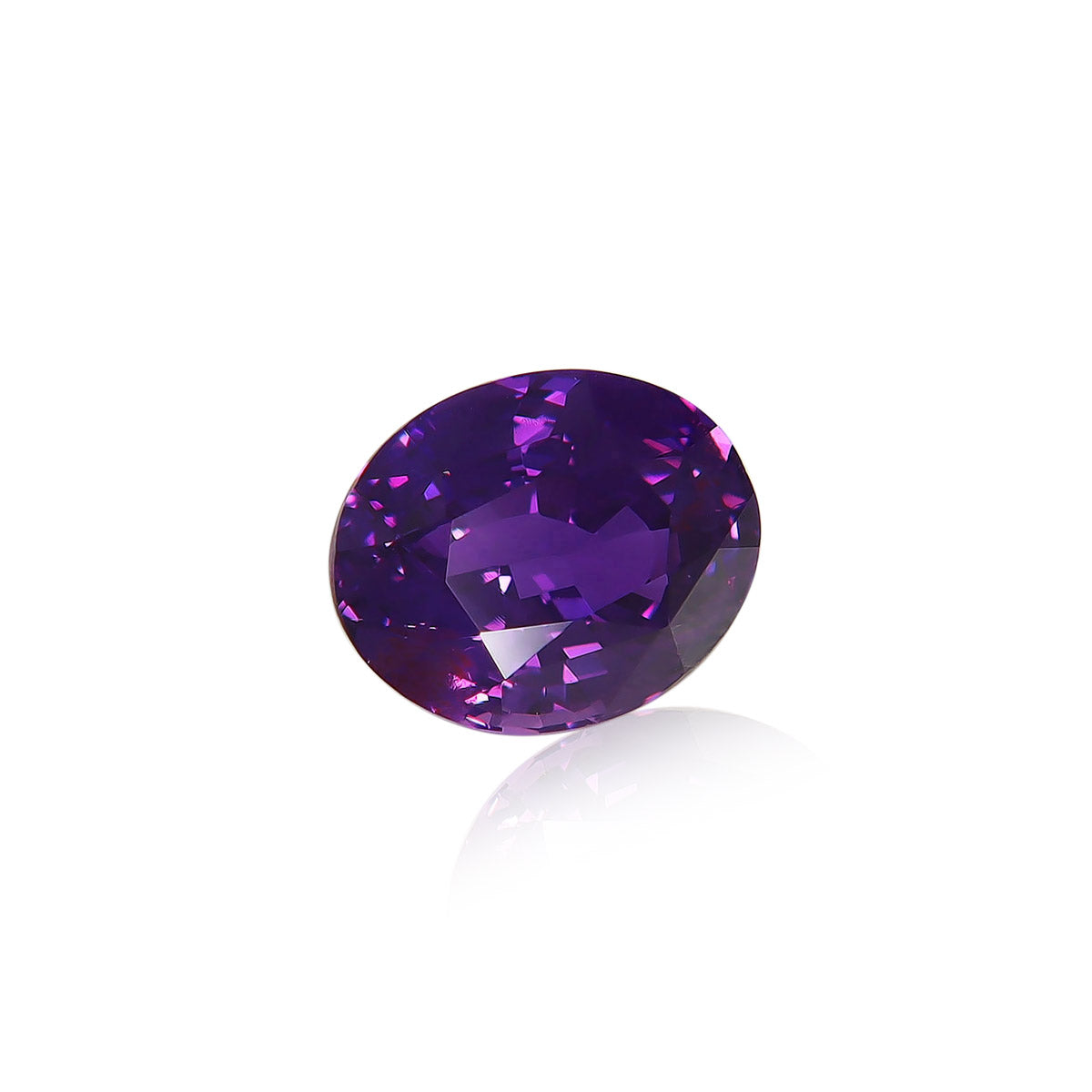 Le Saphir Violet de Bonnot Paris est une pierre précieuse de forme ovale, pesant 2,61 carats, dont la surface facettée révèle des reflets et des nuances violettes éclatantes. Son fond blanc souligne sa clarté et sa profondeur.