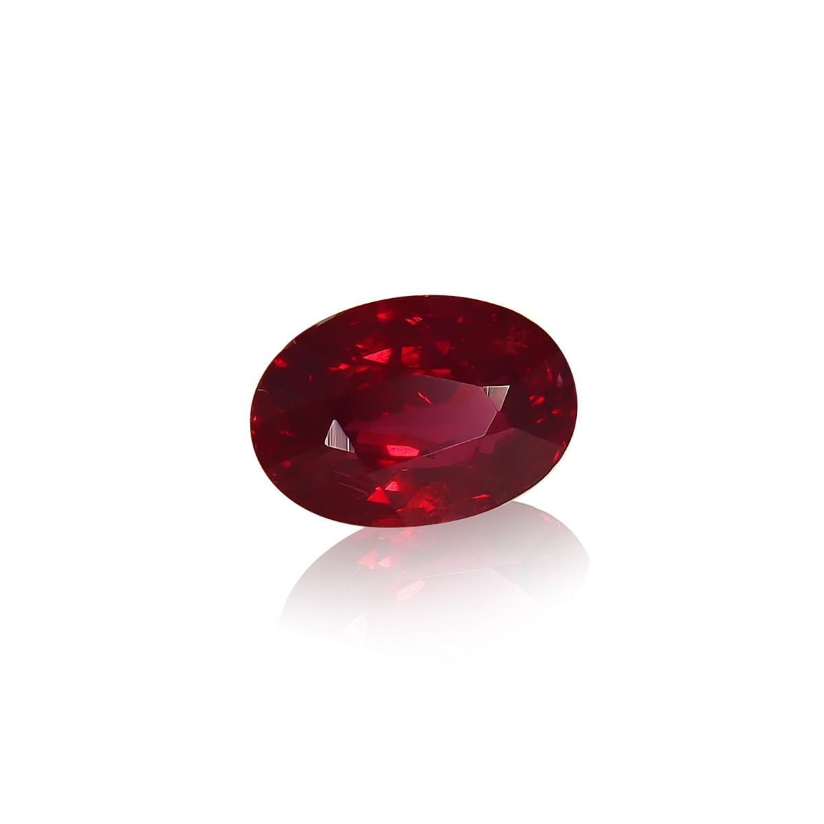 Un rubis du Mozambique rouge vif, taille ovale, de Bonnot Paris, pesant 1,01 ct, repose sur un fond blanc réfléchissant. Sa surface lisse et brillante et ses facettes créent un effet scintillant lorsqu'elles captent la lumière.