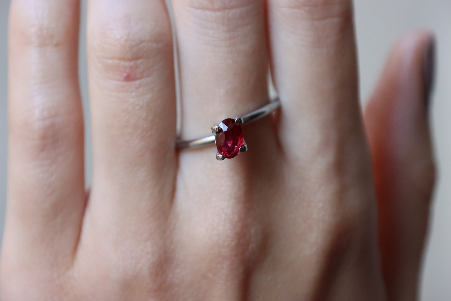 Une belle main porte une bague en argent Bonnot Paris ornée d'un Rubis du Mozambique de 1,01 carat. Cette pierre d'un rouge éclatant se pose élégamment sur l'annulaire, sur un fond subtilement flou.