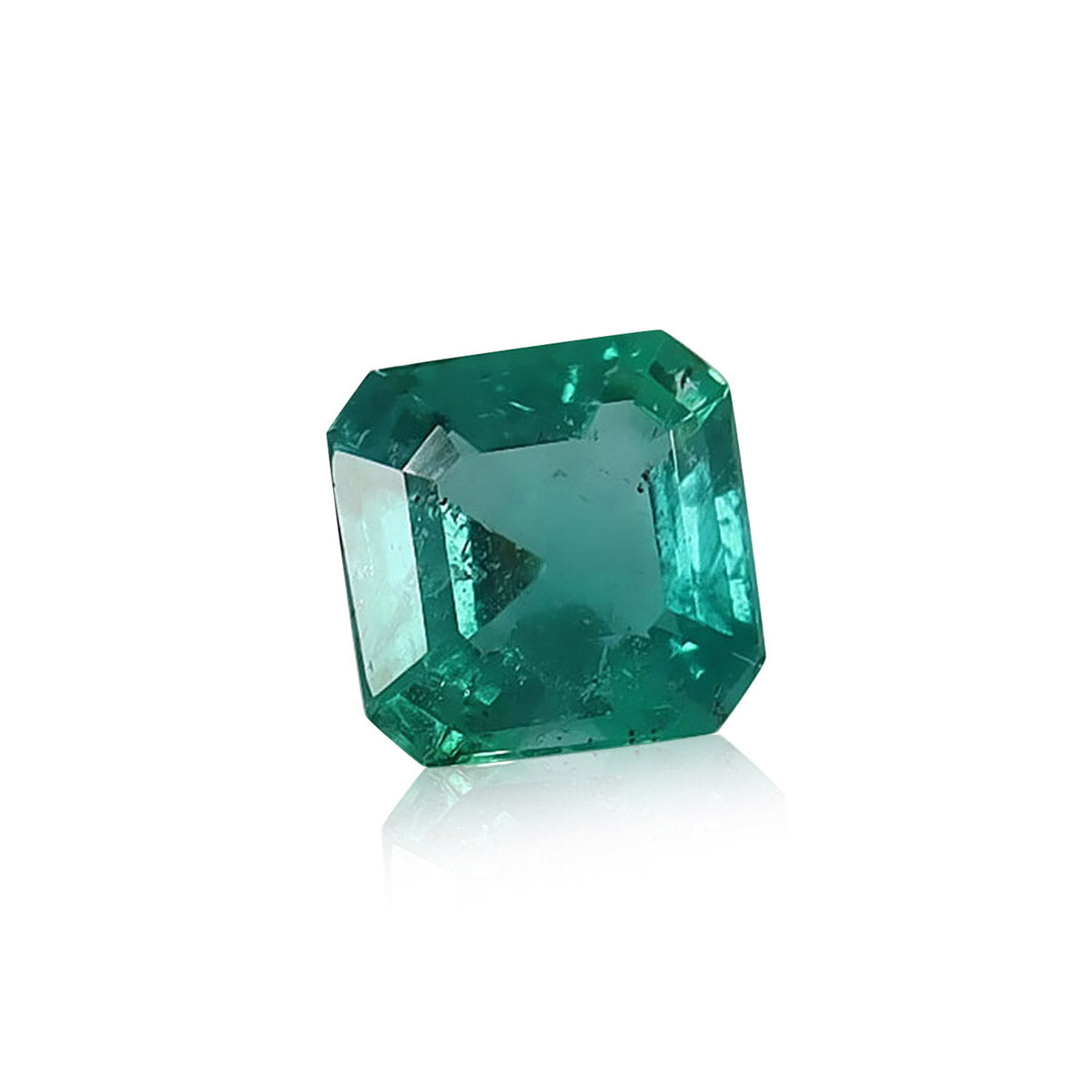 L'Émeraude de Zambie de Bonnot Paris est une émeraude taille carrée de 1,2 carat avec une teinte verte vive et de multiples facettes reflétant la lumière pour un effet lumineux, sur fond blanc uni.