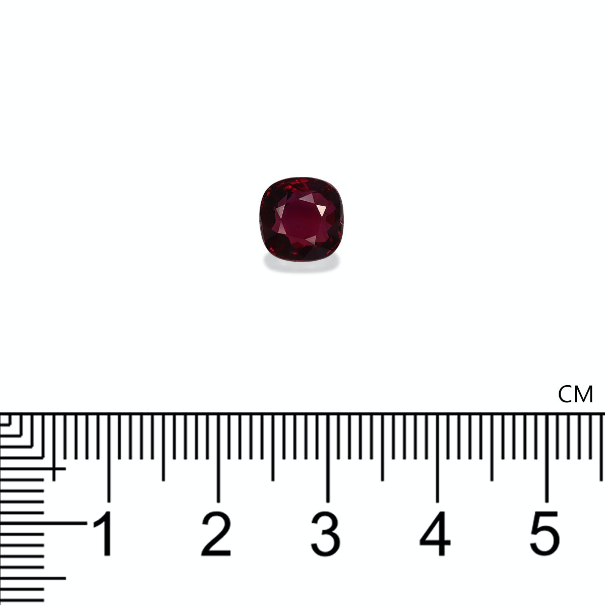 Un Rubis du Mozambique taille coussin, 3,02 ct de Bonnot Paris, est placé au-dessus d'une règle métrique sur fond blanc, montrant sa largeur légèrement supérieure à 1 cm.