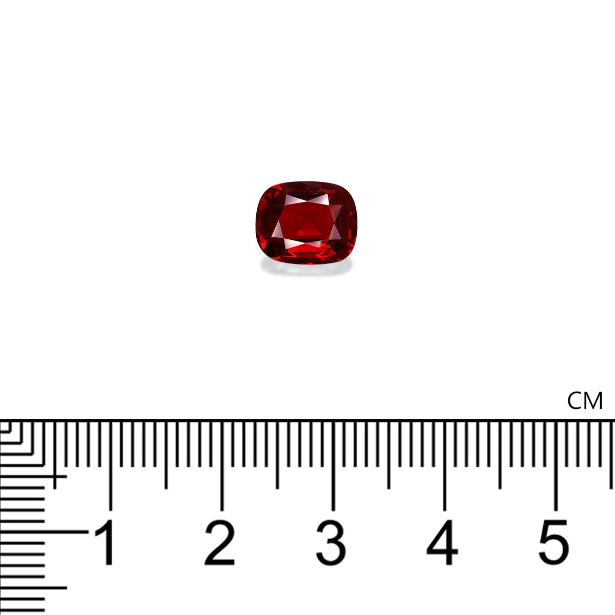 Un Spinelle Rouge taille coussin, de 2,3 ct de Bonnot Paris, repose sur un fond blanc avec une règle graduée en centimètres en dessous, montrant que la pierre mesure un peu plus de 1 cm de large.