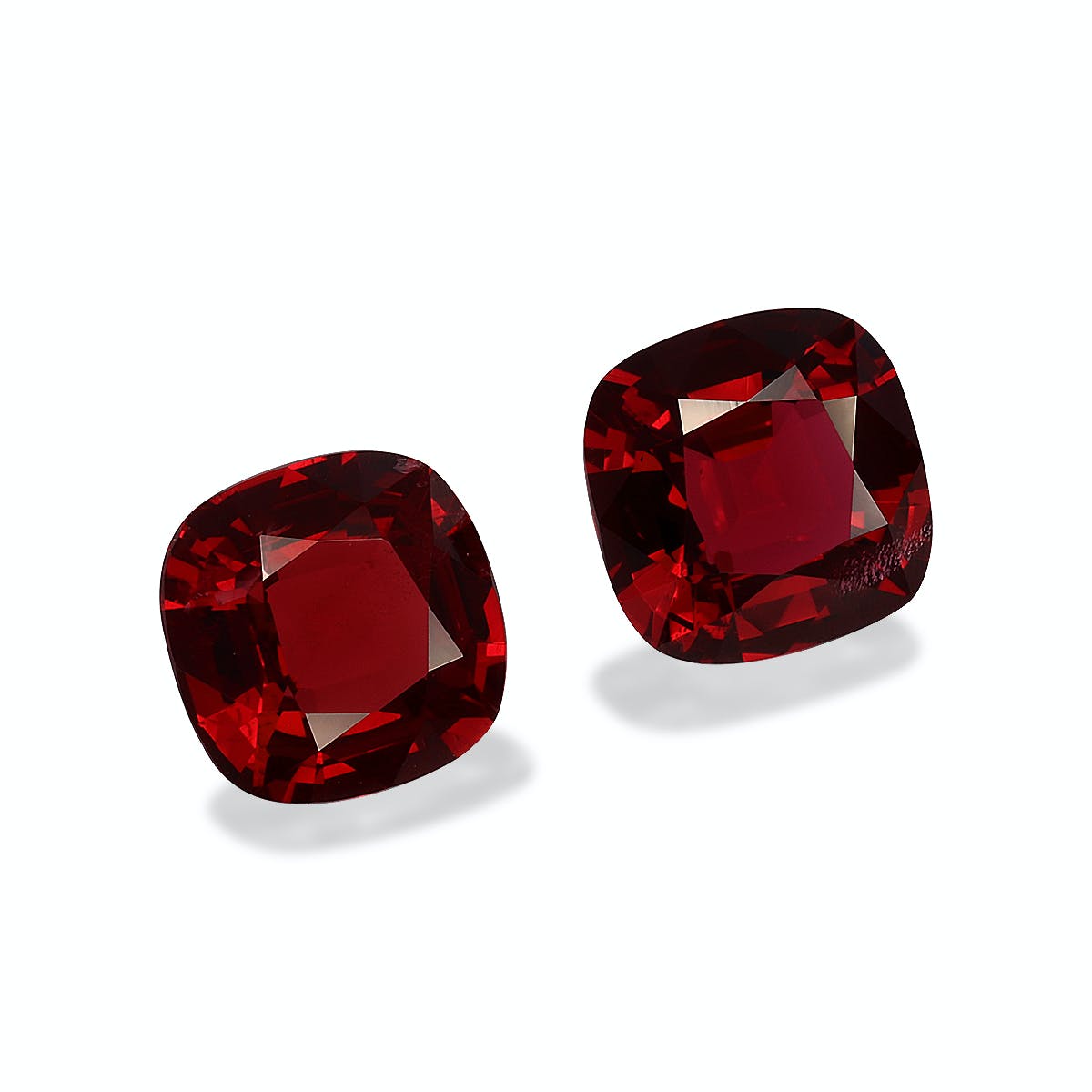 Deux Spinelle Rouge de Bonnot Paris, de 3,49 carats chacune, sont présentées sur fond blanc. Ces pierres de taille carrée présentent des facettes profondes et une finition brillante, affichant une riche teinte rouge foncé, dont les reflets soulignent la complexité de leurs tailles.