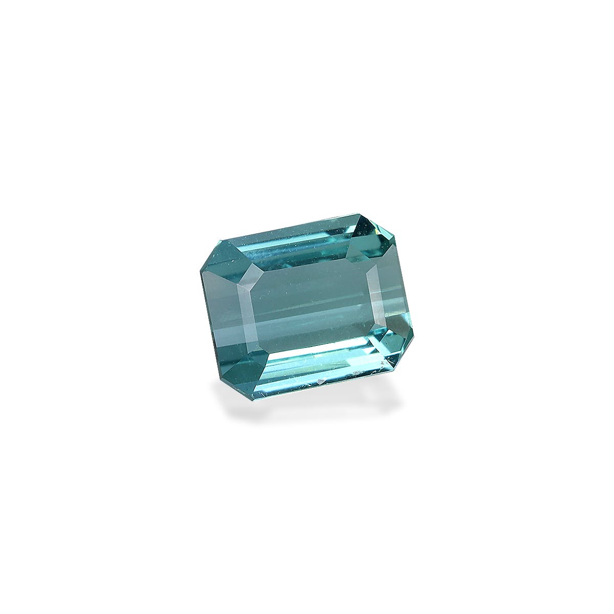 La Tourmaline Bleue de Bonnot Paris est une pierre précieuse taille émeraude rectangulaire de 1,47 ct avec une teinte bleu clair et une clarté transparente, reflétant magnifiquement la lumière sur un fond blanc.