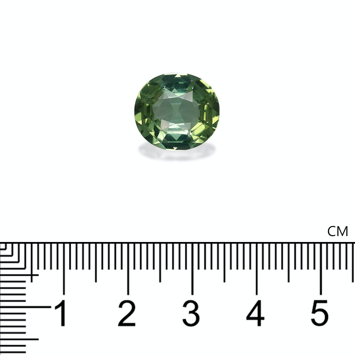 La Tourmaline Verte Bonnot Paris · 6,17 ct, une petite pierre précieuse verte de taille ovale, scintille avec des facettes réfractant la lumière alors qu'elle repose au-dessus d'une règle centimétrique, qui indique sa taille à environ 1,5 cm de longueur sur un fond blanc uni.