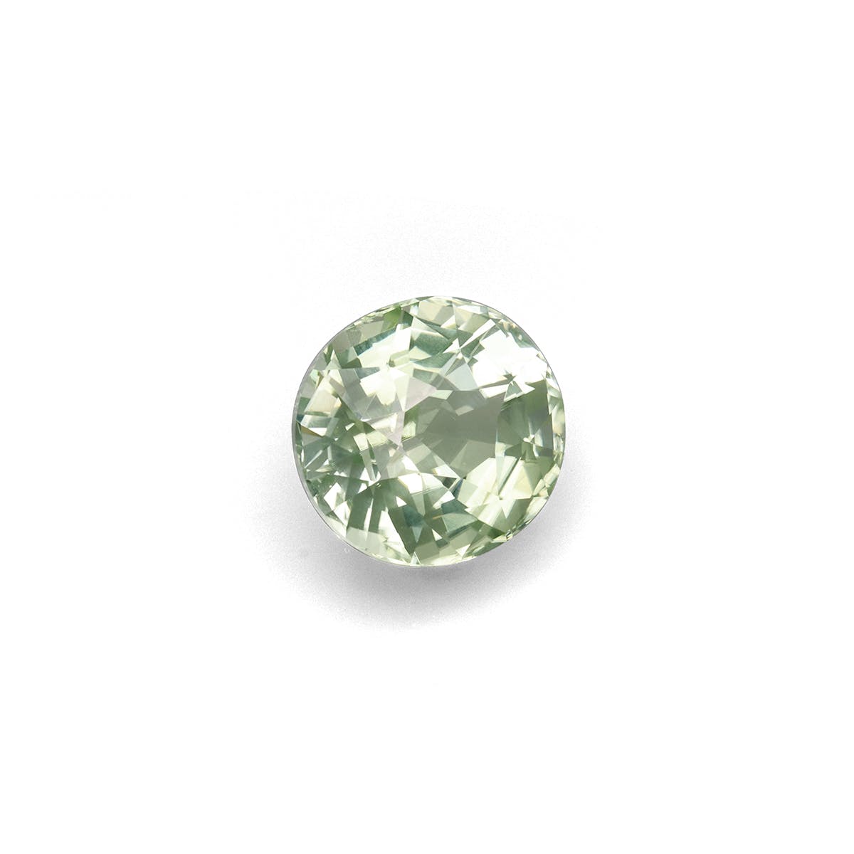Une Tourmaline Verte Bonnot Paris · 7,79 ct, ronde et facettée, scintille d'une teinte verte translucide sur un fond blanc uni, ses facettes créant un effet de lumière chatoyant.