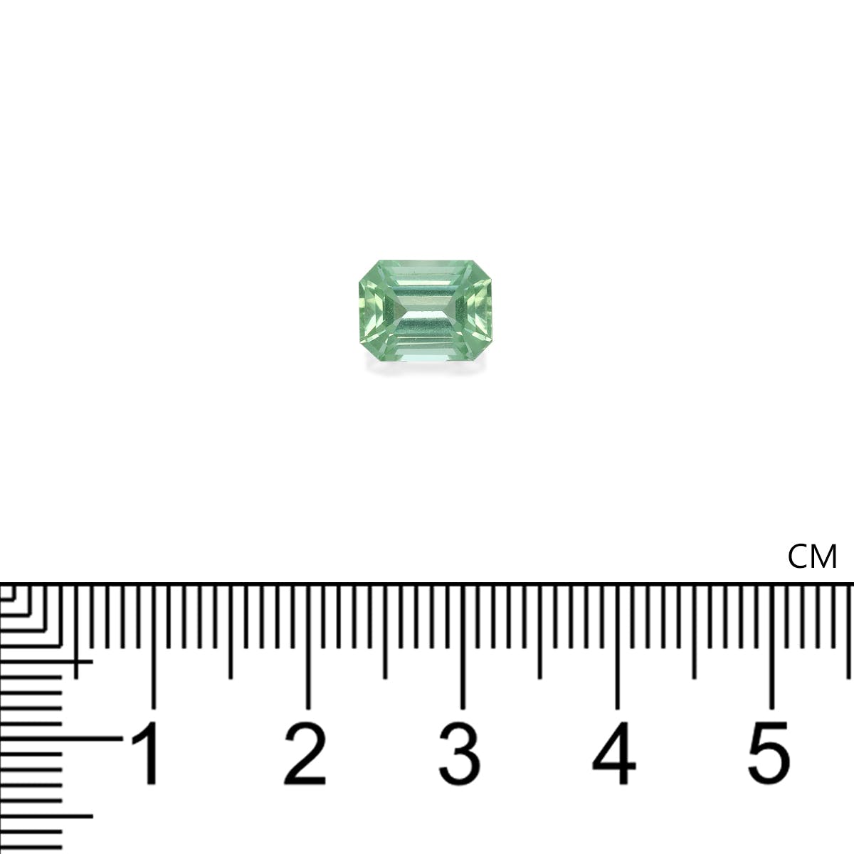 Une tourmaline verte de 2,43 carats de Bonnot Paris, taille émeraude et à facettes étagées, est présentée à côté d'une règle graduée. D'un vert clair et doux, elle mesure un peu plus d'1 cm de large.