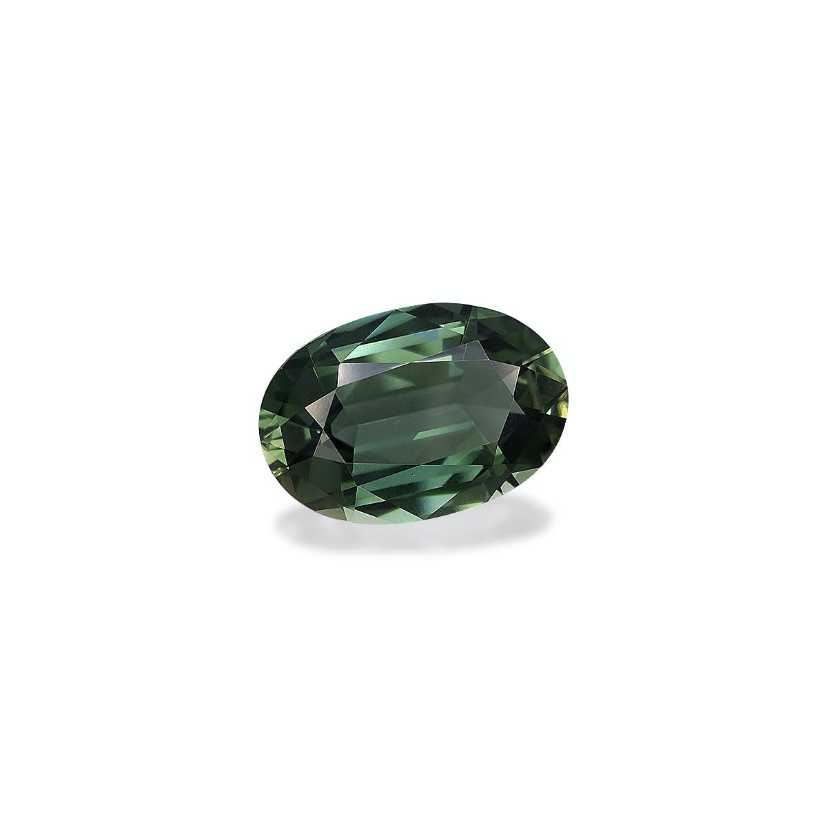 La 'Tourmaline Verte' de Bonnot Paris est une pierre précieuse verte verdoyante de 6,94 carats de forme ovale et aux multiples facettes, projetant une ombre subtile sur un fond clair.
