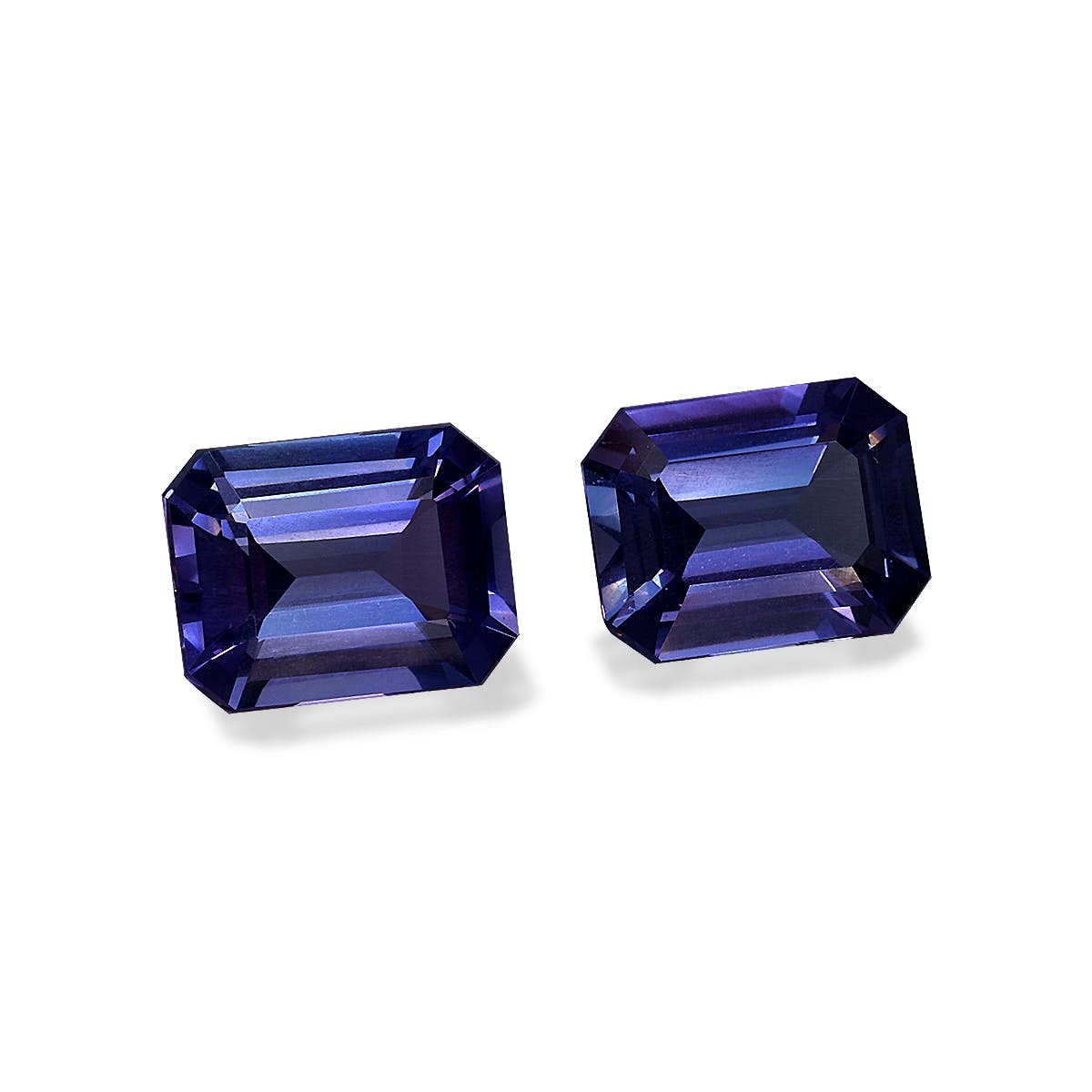 Deux tanzanites facettées, totalisant 5,82 carats, présentent des tailles rectangulaires aux teintes bleu profond et aux reflets violets. Proposées par Bonnot Paris, elles reposent sur un fond blanc aux angles légèrement différents.