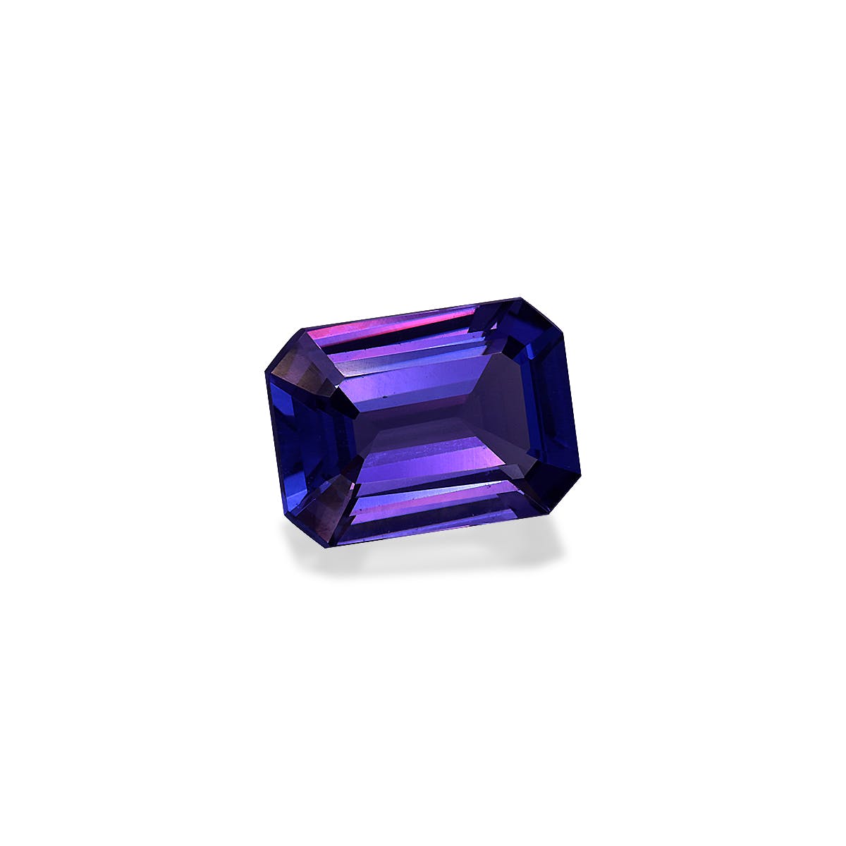 La Tanzanite · 2,34 ct de Bonnot Paris est une pierre précieuse facettée taille émeraude présentant un mélange de teintes bleu foncé et violet sur un fond blanc uni.