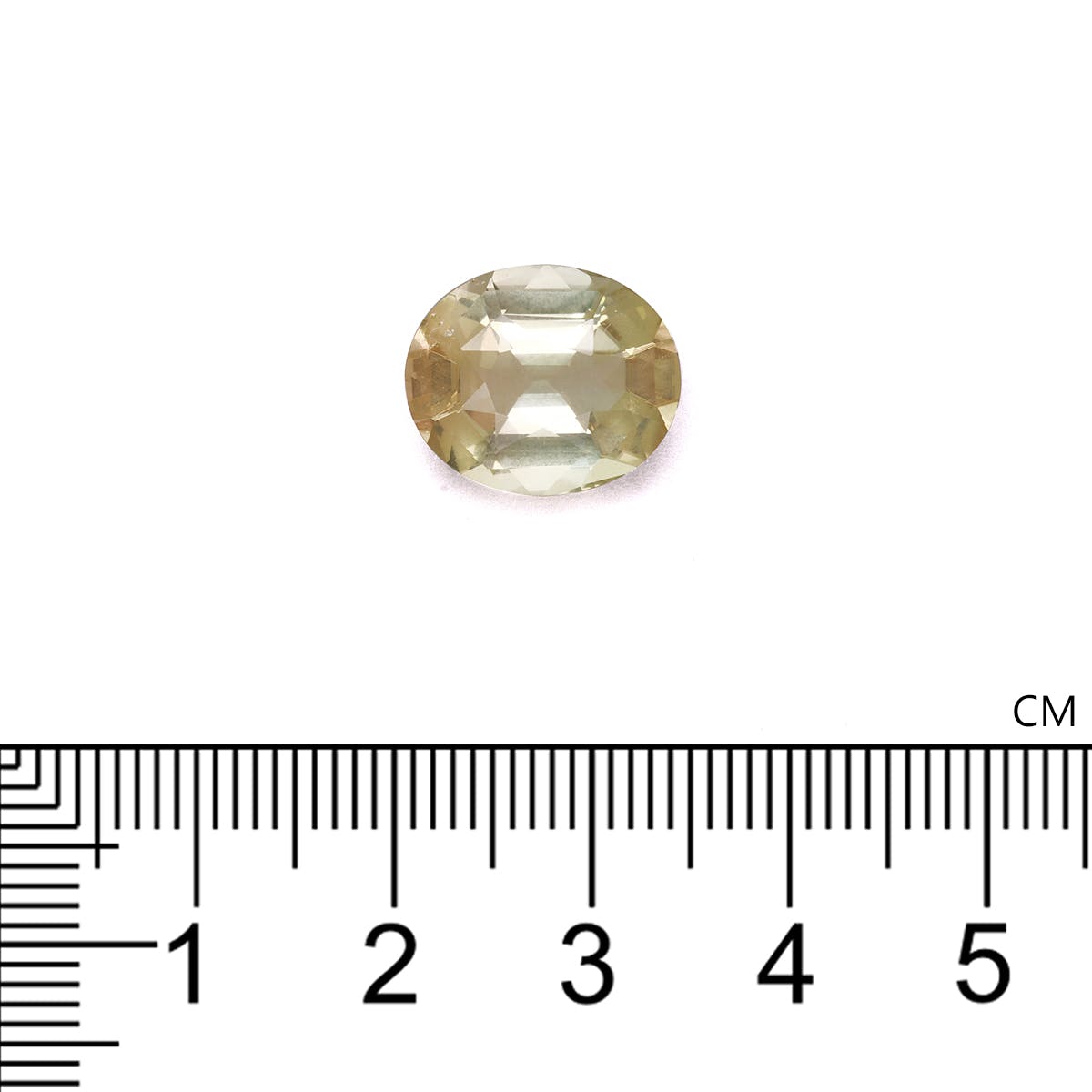 Une petite Tourmaline Jaune taille ovale · 6,64 ct de Bonnot Paris est placée sur une surface blanche au-dessus d'une règle graduée en centimètres, et elle semble mesurer environ 1,5 à 2 cm de longueur.