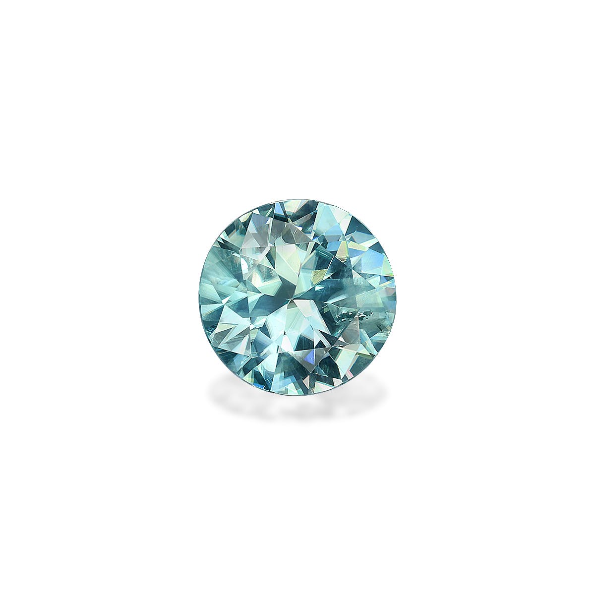 Le Zircon Bleu · 3,25ct de Bonnot Paris, pierre précieuse ronde facettée, présente une teinte bleu-vert clair sur fond blanc, ses facettes scintillantes reflétant la lumière.