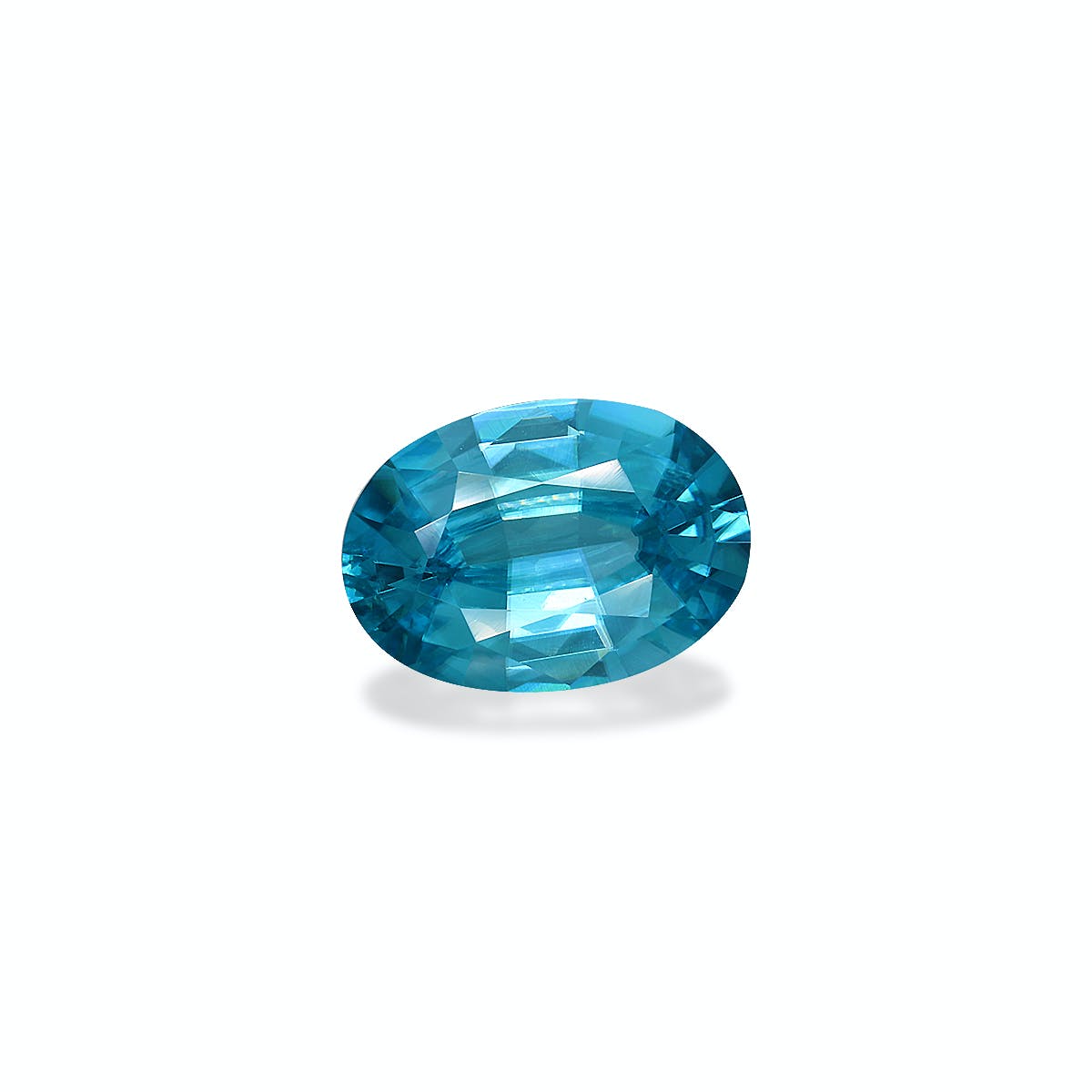 Le Zircon Bleu de Bonnot Paris est une pierre précieuse bleue de forme ovale de 5,79 ct aux facettes complexes, sertie sur un fond blanc uni, capturant et réfléchissant la lumière pour mettre en valeur sa teinte bleue vibrante et riche.