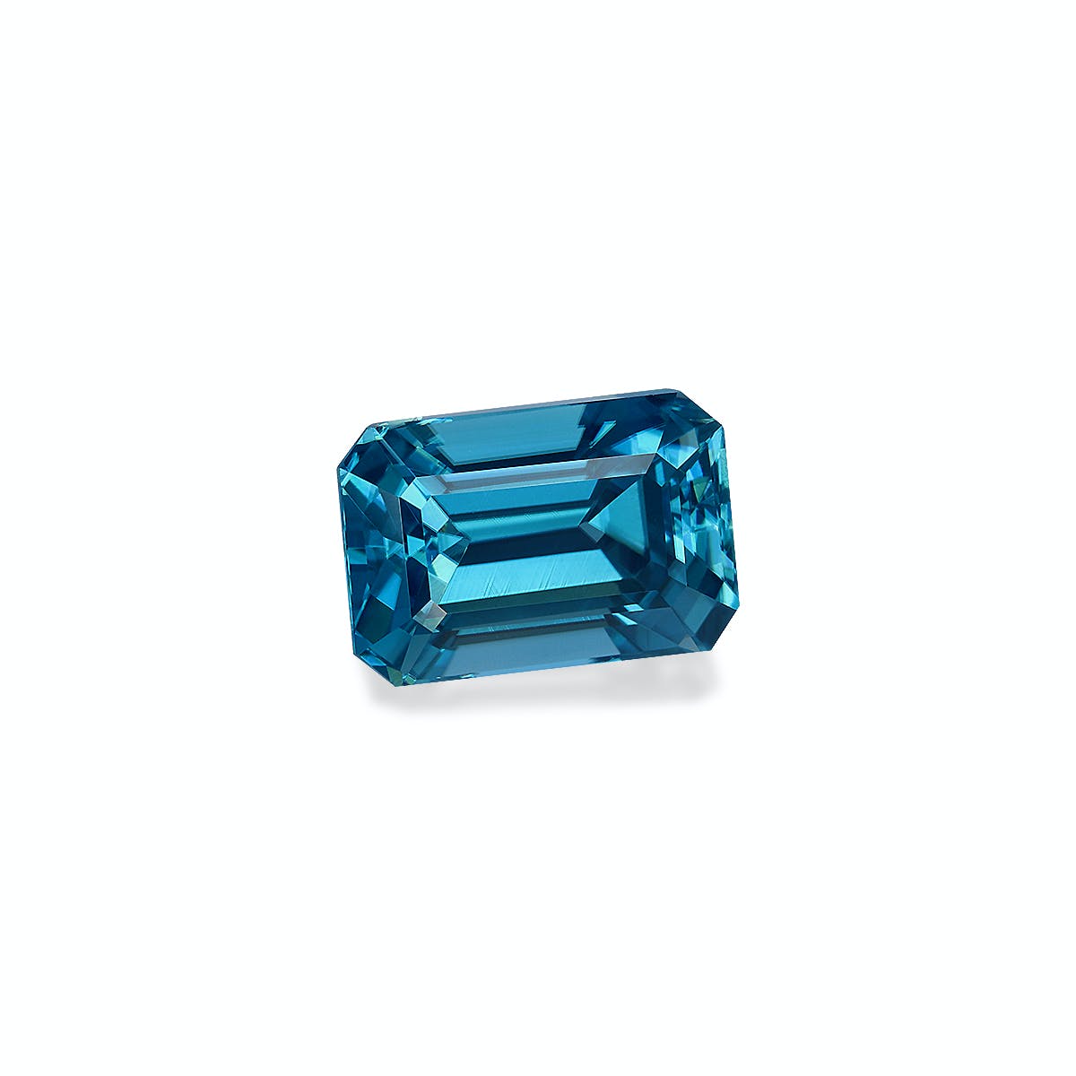Un Zircon Bleu facetté taille émeraude de 4,29 carats signé Bonnot Paris est serti sur un fond blanc uni. Transparent, il présente des nuances d'un bleu profond, des arêtes nettes et des surfaces réfléchissantes qui soulignent son éclat et sa clarté.