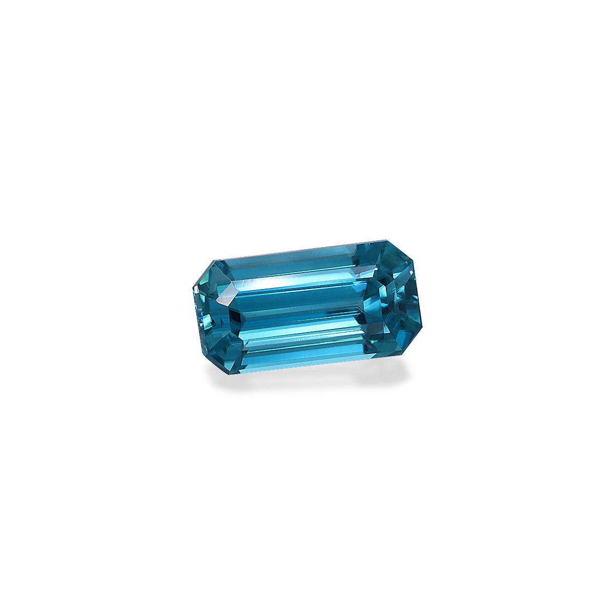 Le Zircon Bleu de Bonnot Paris est une pierre précieuse aigue-marine facettée de 4,44 ct de forme octogonale allongée, de couleur bleue vibrante, et placée sur un fond clair pour mettre en valeur sa clarté et ses facettes réfléchissantes.