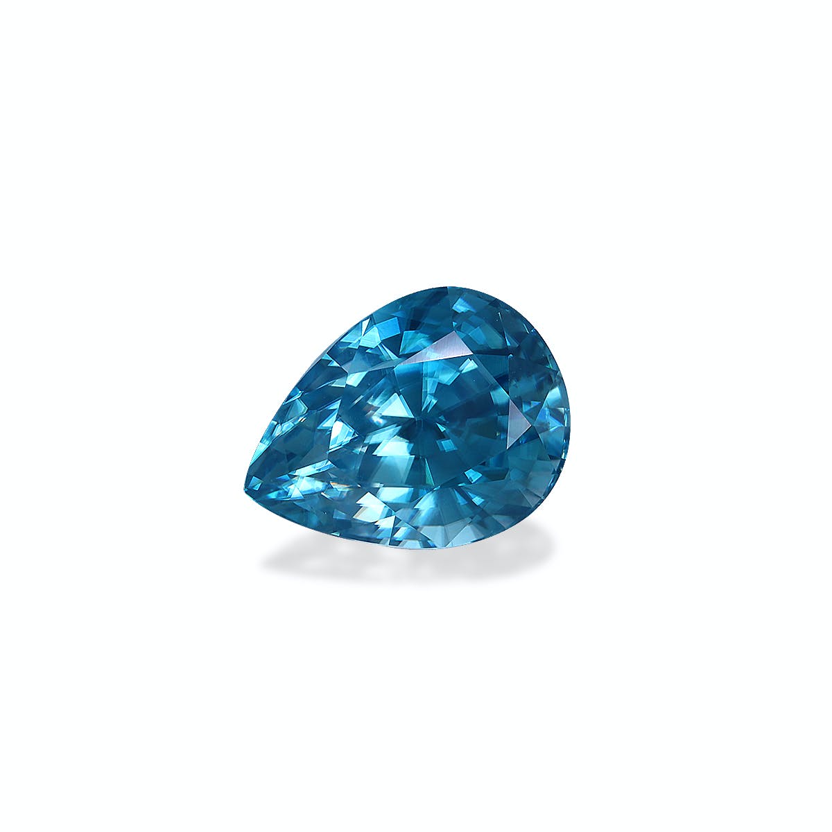 Le Zircon Bleu · 7,75 carats de Bonnot Paris est une pierre précieuse bleue facettée, en forme de poire, sertie sur un fond blanc uni. Son design reflète magnifiquement la lumière, révélant des nuances de bleu vibrantes et un éclat exquis.