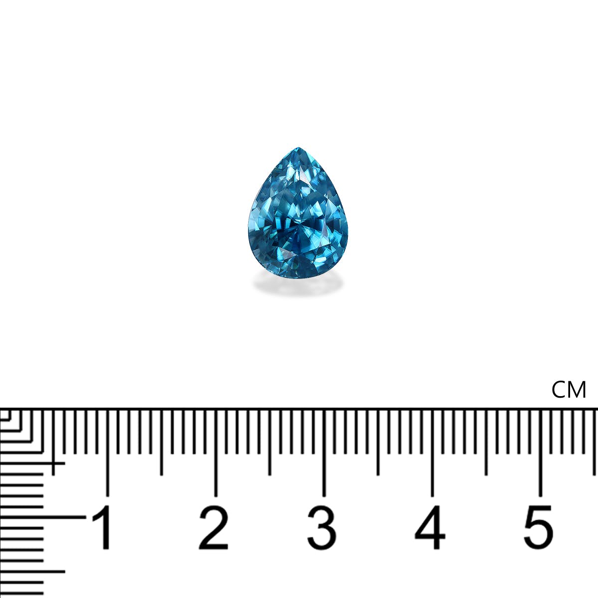 Un Zircon Bleu de 7,75 carats de Bonnot Paris, en forme de petite poire, est placé au-dessus d'une règle centimétrique à la marque de 2 cm, mettant en valeur sa taille sur un fond blanc qui met en valeur ses facettes complexes et son éclat.