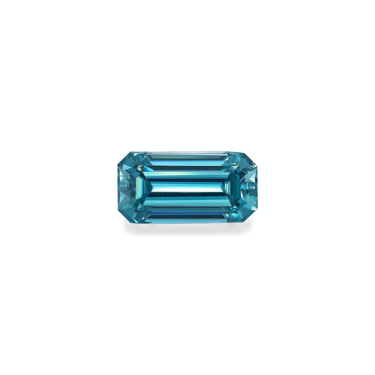 Le Zircon Bleu · 4,75 ct de Bonnot Paris est une pierre précieuse bleue facettée, taille émeraude, de forme rectangulaire allongée et aux coins biseautés, présentée sur un fond blanc uni pour plus de clarté et de brillance réfléchissante.