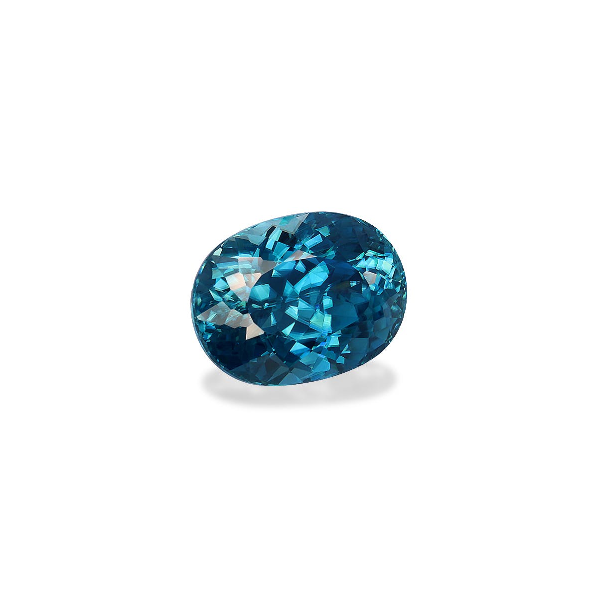 Le Zircon Bleu · 6,12ct de Bonnot Paris est une pierre précieuse bleue polie, taille ovale, avec des surfaces facettées reflétant la lumière, sertie sur un fond blanc uni.
