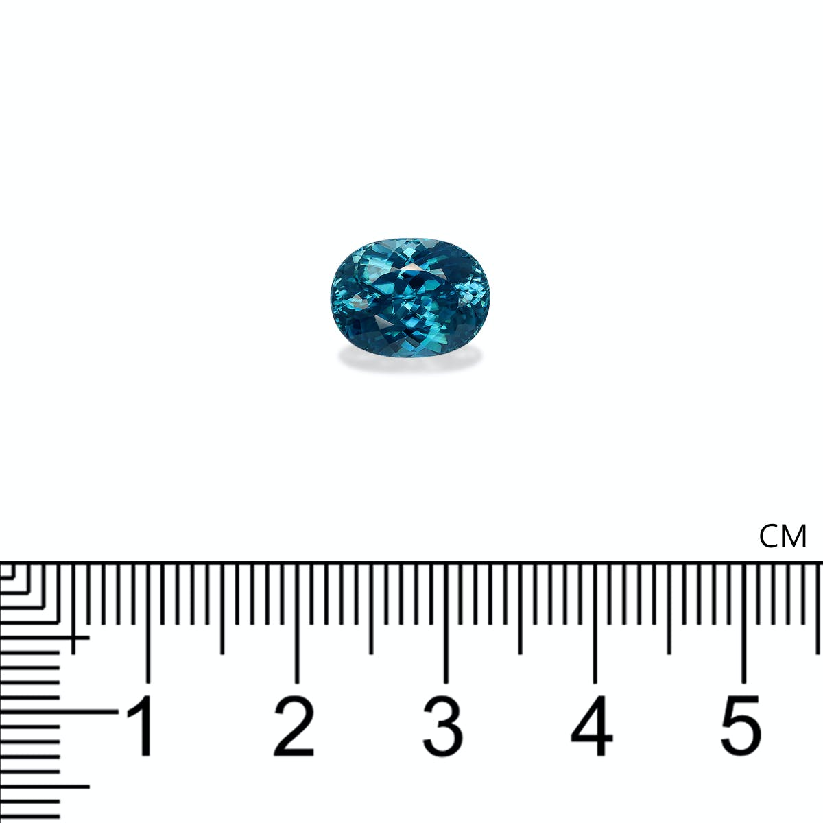 Une pierre précieuse Zircon Bleu · 6,12 ct de Bonnot Paris, présentant un design sarcelle de taille ovale, est présentée sur un fond blanc à côté d'une règle centimétrique indiquant sa taille de moins d'un centimètre de longueur.