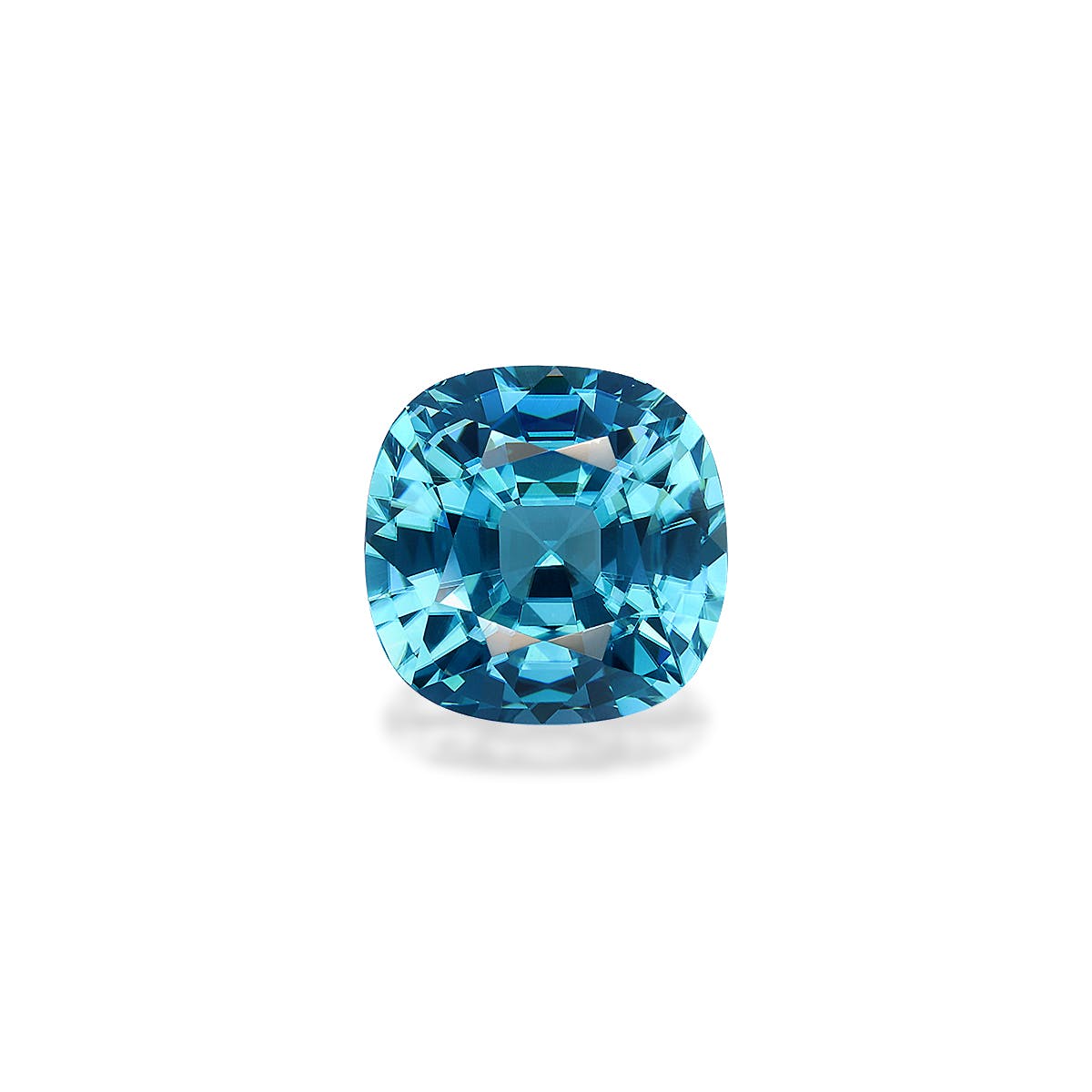 Le Zircon Bleu · 8 carats de Bonnot Paris est une pierre précieuse taille coussin aux facettes complexes, reflétant la lumière sur un fond blanc uni. Sa couleur bleue éclatante rehausse son éclat et sa clarté.