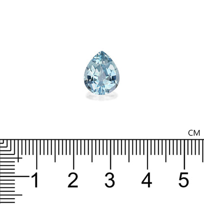 L'Aigue-Marine de 3,85 carats de Bonnot Paris, une petite pierre précieuse en forme de poire, repose élégamment sur une surface blanche. En dessous, une règle métrique souligne sa longueur sophistiquée de 1 cm.