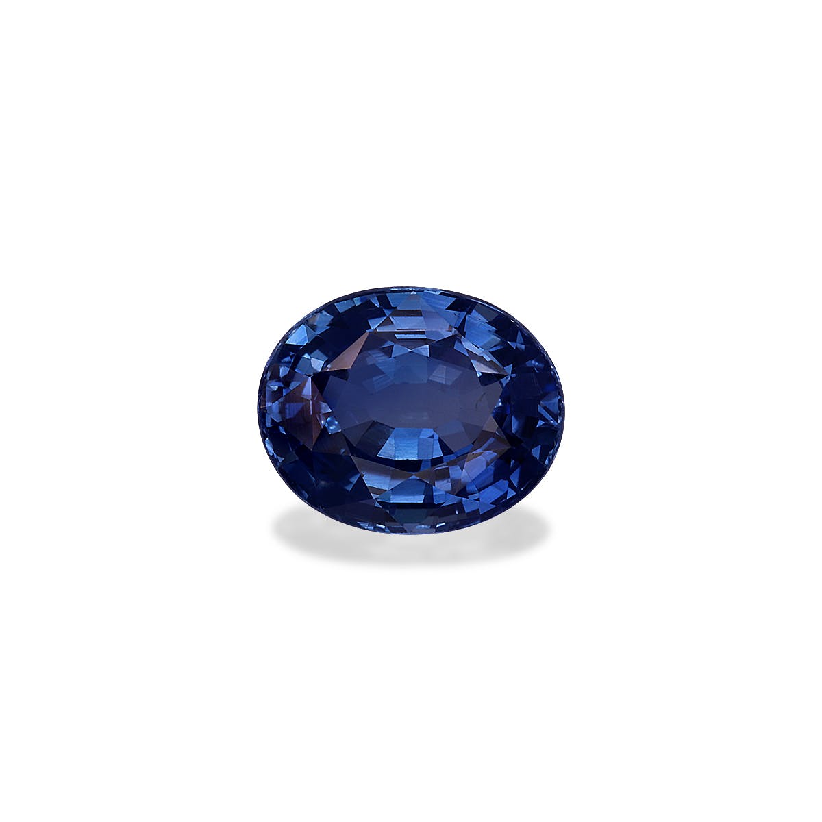 Le Saphir Bleu · 2,04 ct de Bonnot Paris est une pierre précieuse saphir bleu ovale sertie sur un fond blanc uni, ses facettes polies reflétant la lumière, soulignant sa riche teinte bleue.