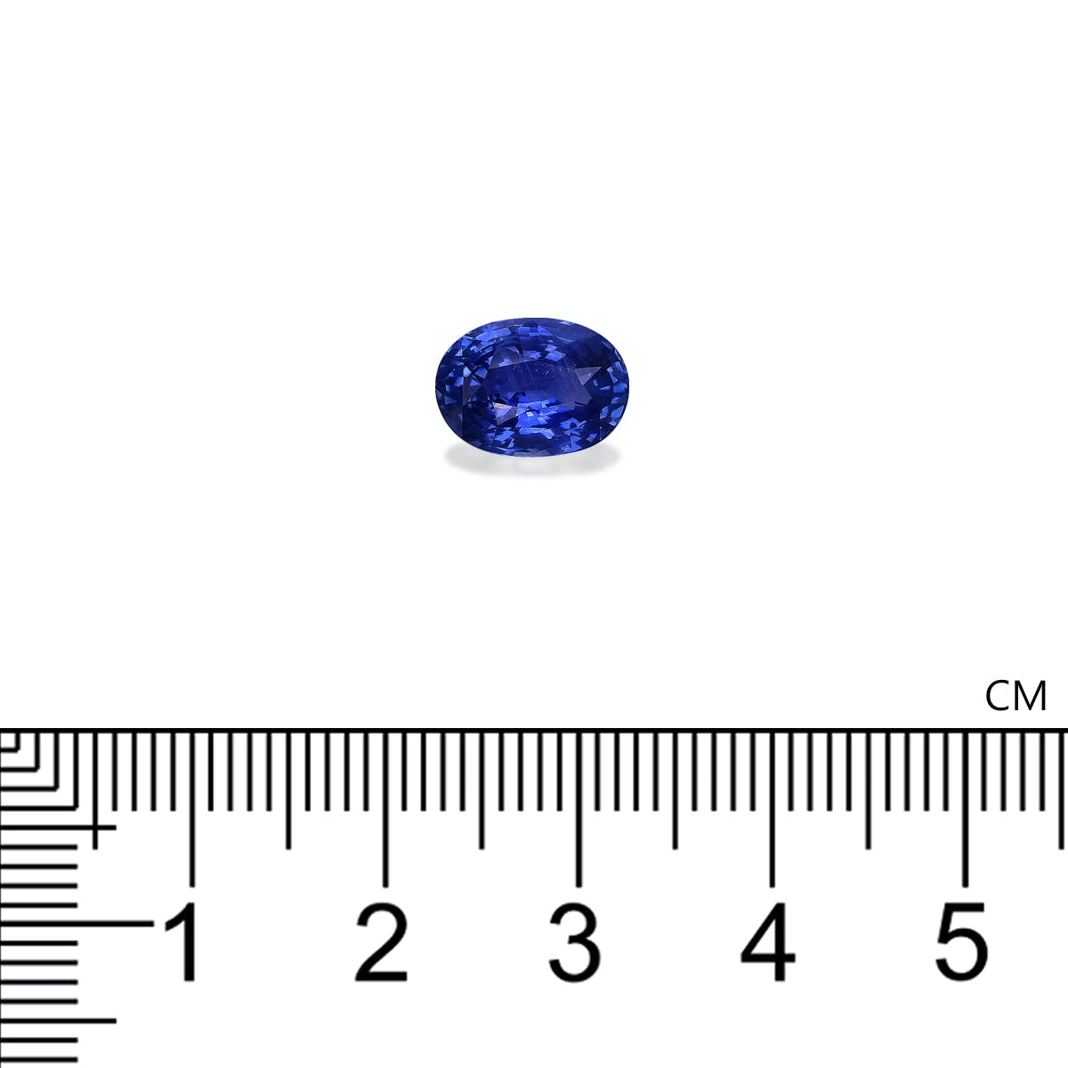 Le Saphir Bleu · 3,22ct de Bonnot Paris, une petite pierre précieuse bleue de forme ovale, est représenté sur un fond blanc à côté d'une règle centimétrique, indiquant qu'il mesure environ 1 cm de longueur.